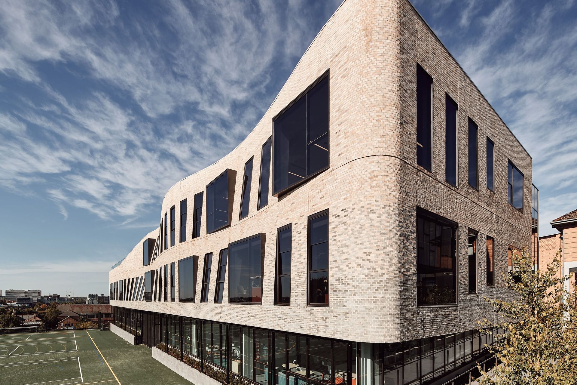 This textured facade of Petersen bricks forms a curved veil