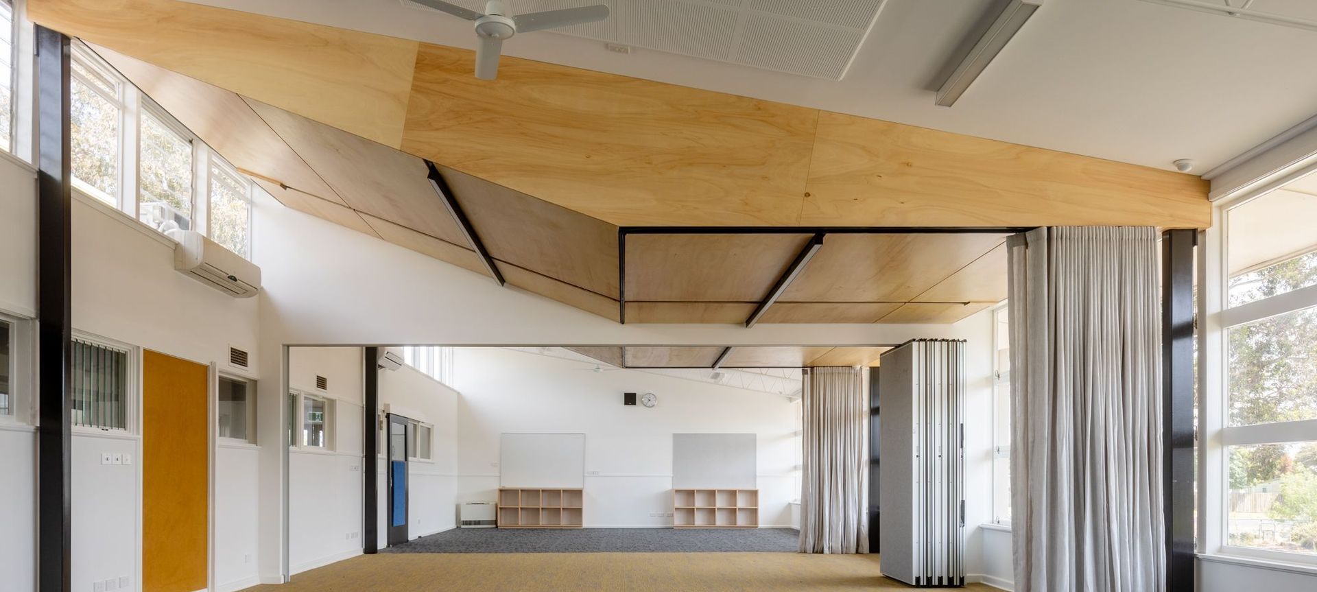 Light wood panelling, integrated lights and provide a bright learning space