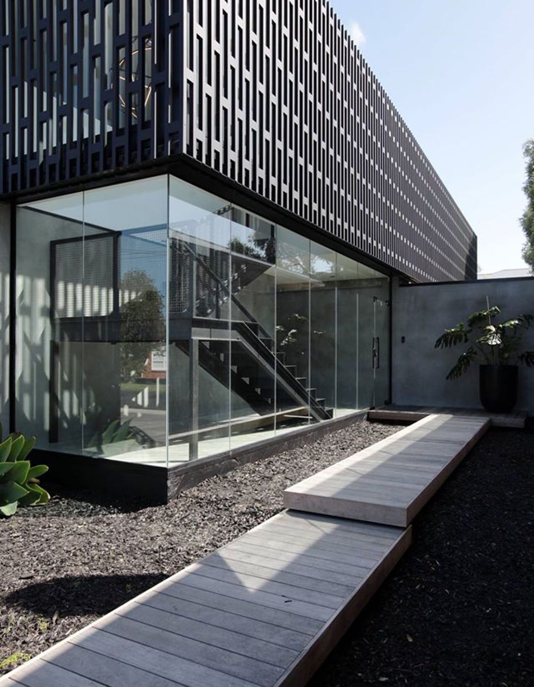 The full-height, fully glazed entry—which encases a statement staircase—serves as a dramatic keynote upon arrival.