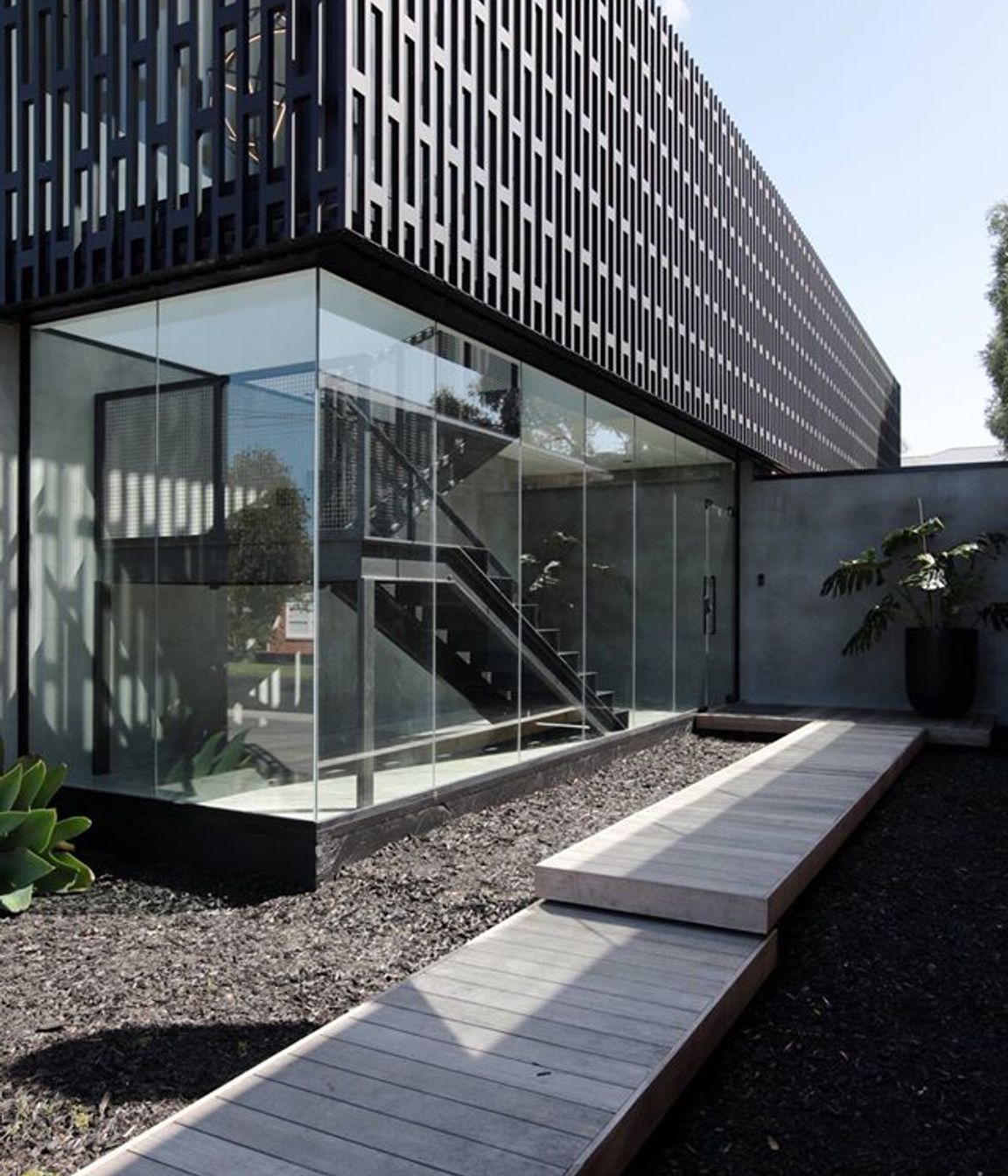 The full-height, fully glazed entry—which encases a statement staircase—serves as a dramatic keynote upon arrival.