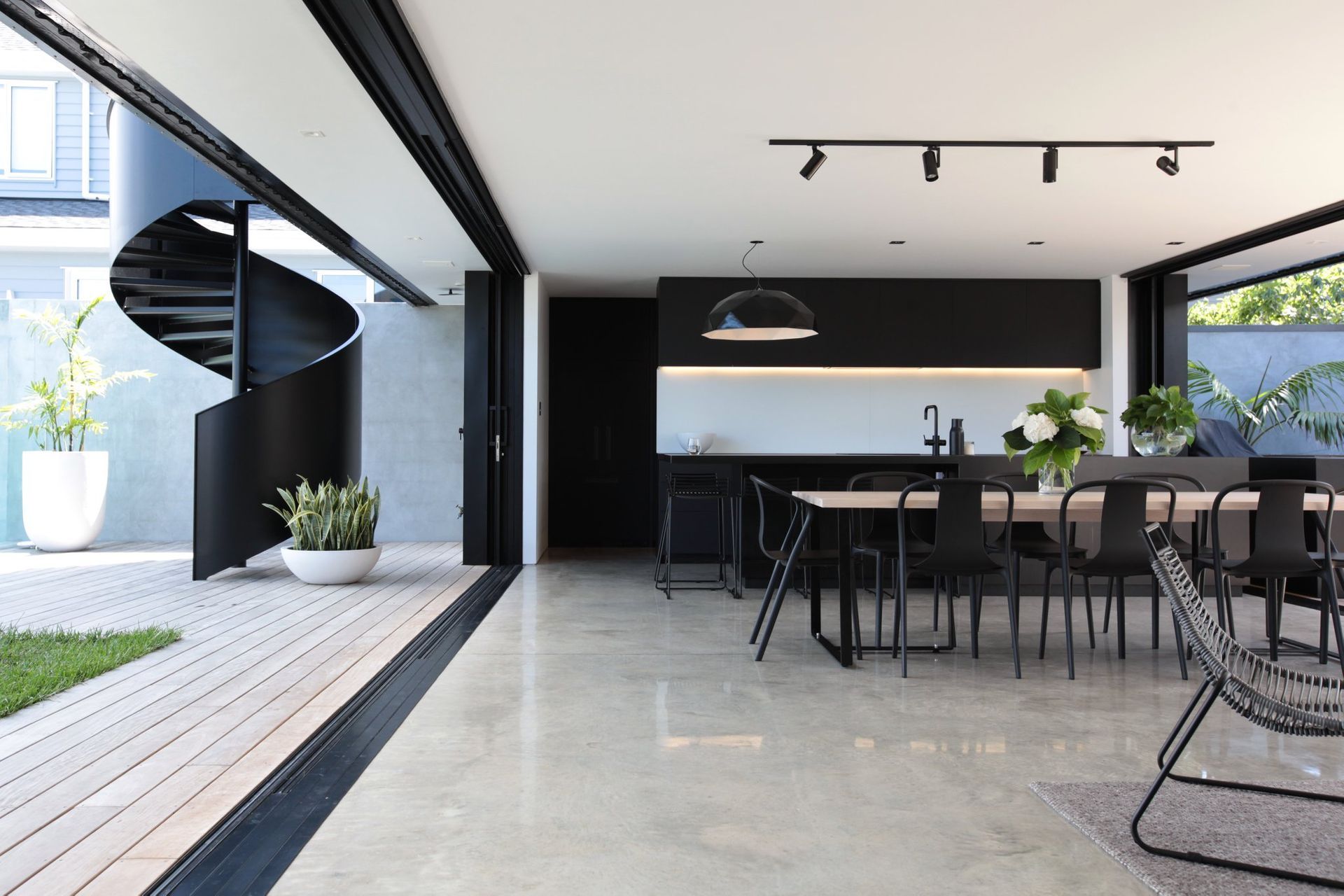 Full-width sliding doors retreat into the walls when open, creating a sense that the living are is a covered outdoor terrace.