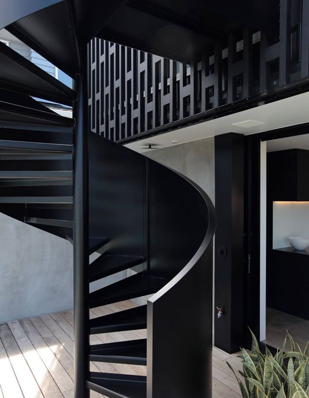 At the other end of the house and on the other side a spiral staircase affords the owners direct access to the backyard from the upper level main bedroom.