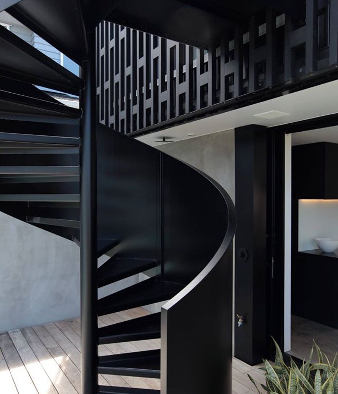At the other end of the house and on the other side a spiral staircase affords the owners direct access to the backyard from the upper level main bedroom.