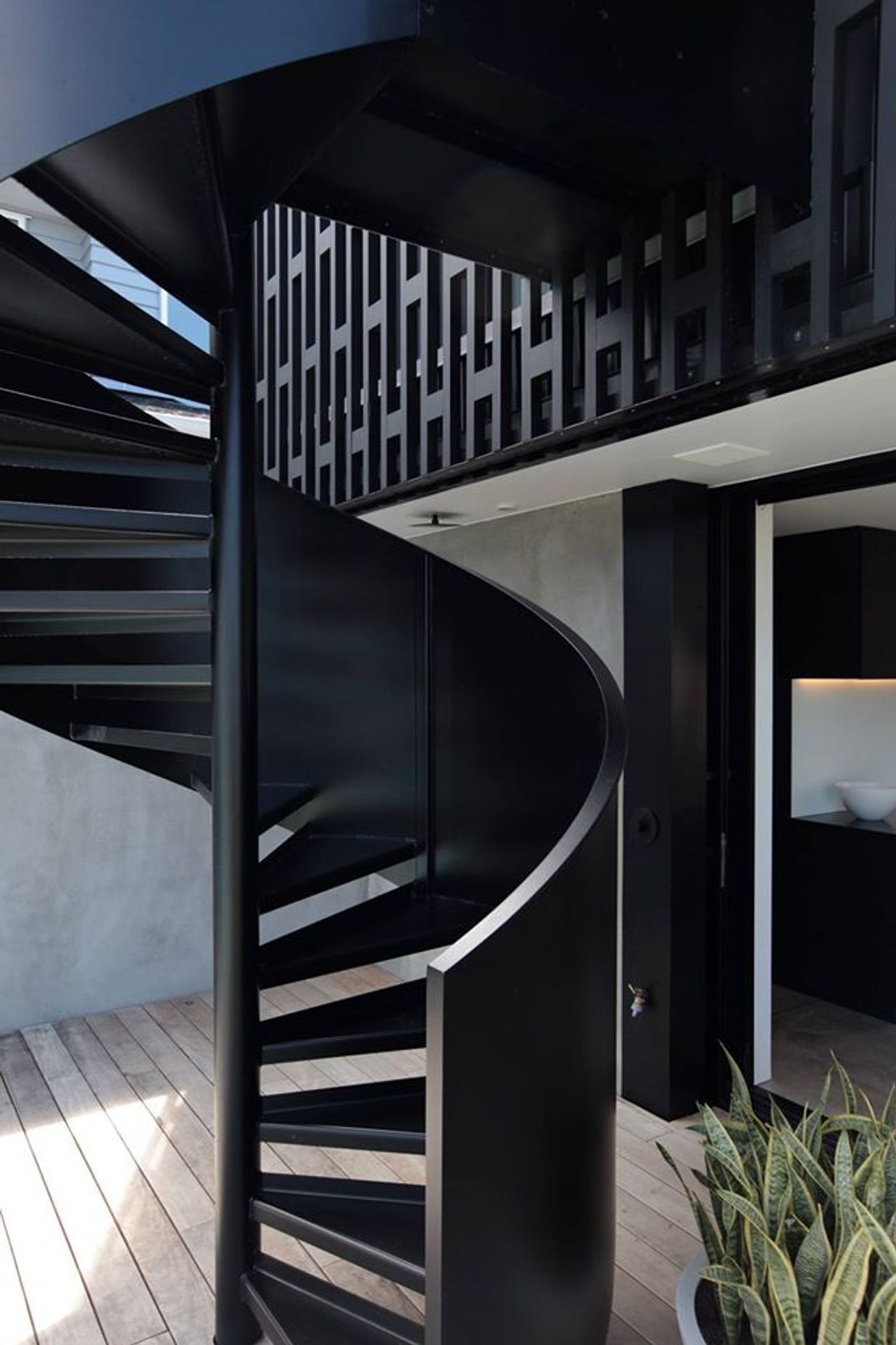 At the other end of the house and on the other side a spiral staircase affords the owners direct access to the backyard from the upper level main bedroom.