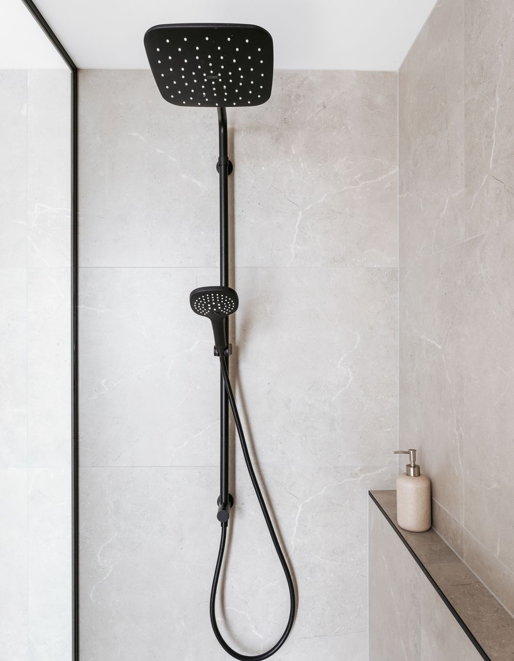 Black fixtures contrast against the stone tiling.