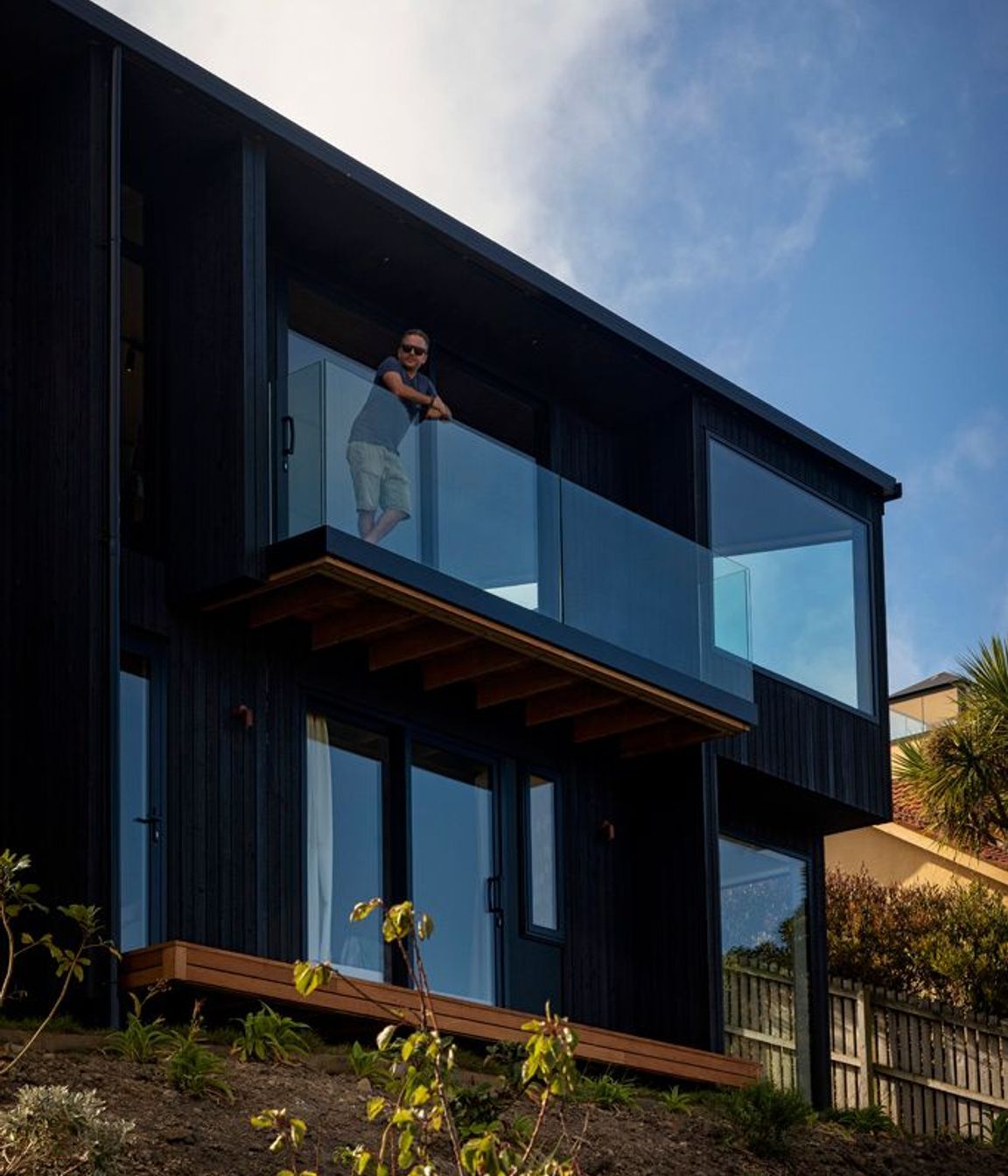The East-facing facade features large-scale glazing to maximise views out across the bay and adjacent headland.