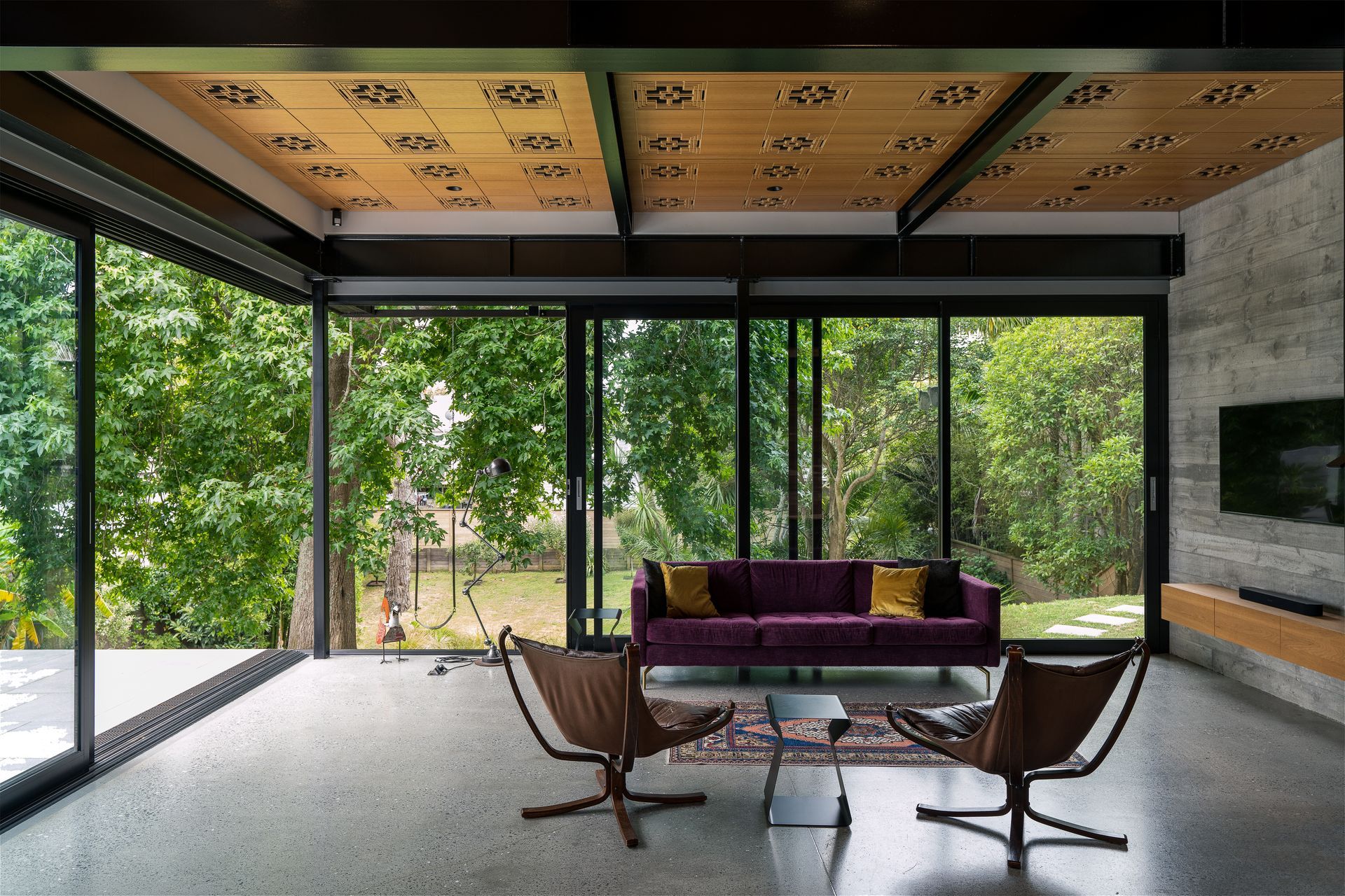 The custom routed acoustic ceiling pattern was inspired by Frank Lloyd Wright. The homeowners found the two Falcon chairs online. “That classic Swedish modern style fits perfectly within those Case Study Houses that were one of the design precedents for this project. The purple couch we had made by BoConcept because we just wanted a splash of colour. Before becoming an architect, I did a degree in underwater archaeology and excavated boats. One of the projects I worked on was in Turkey, where I bought this rug for my then-girlfriend who's now my wife.”