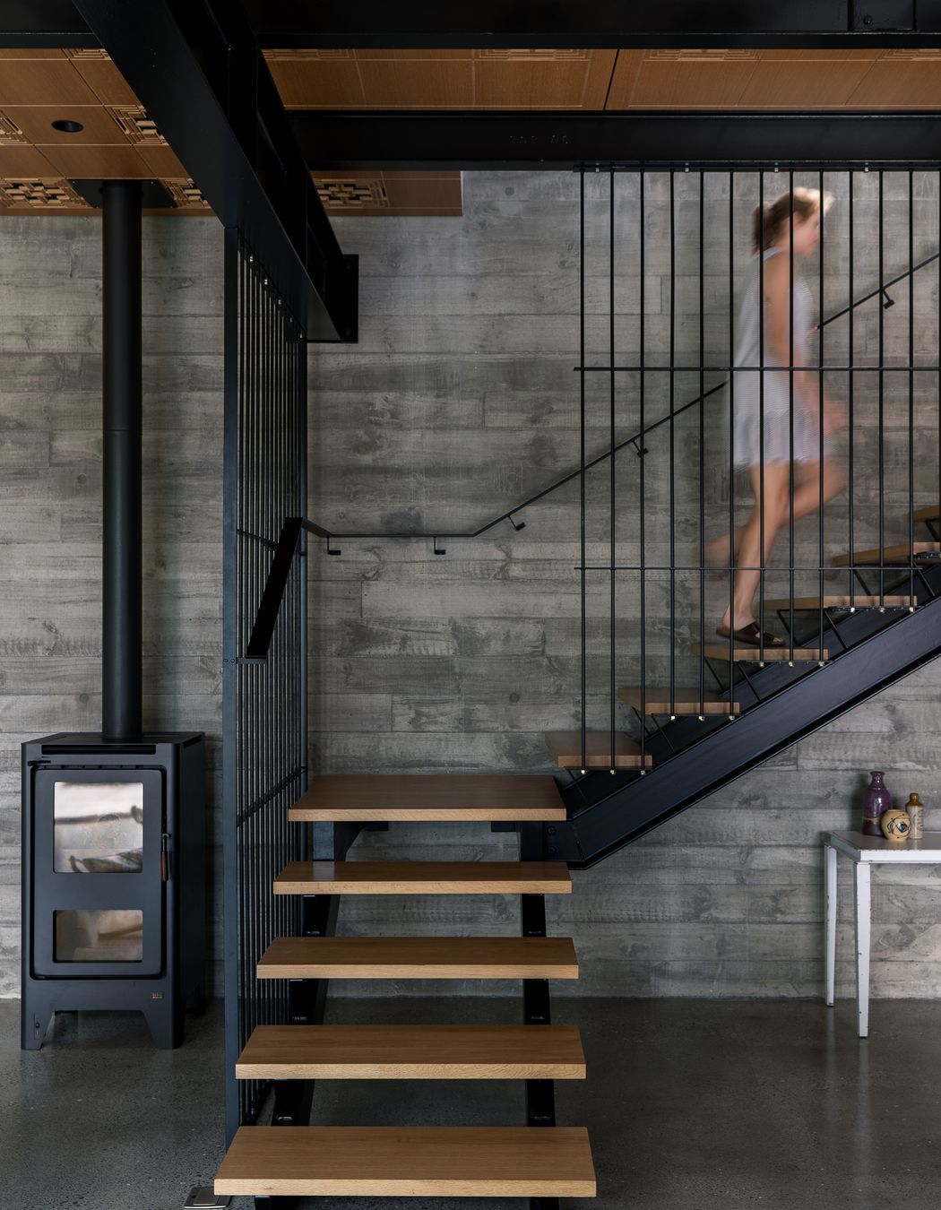 “That fireplace basically heats all of this area. We do have some ducted heat pumps. But to be honest, in the summer, we leave all the windows open and don't need it and in the winter, we light the fireplace at five o'clock and it heats the house all evening.” Clive has collected some second-hand furniture. “I like something that's got a little life to it. It's got a history rather than something brand new.” The Michael Draper table under the stairs was bought when he closed down his factory. “So I've just cleaned all the grease off it, and we've had it for years. I keep putting it into whichever house we live in.”