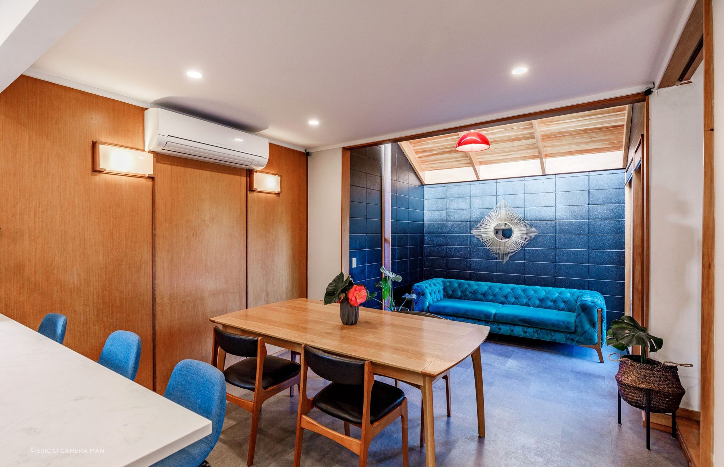 The client cherished the existing timber veneer wall, which we preserved. Removing two walls expanded the space, and the veneer wall now serves as a charming backdrop for the dining area.