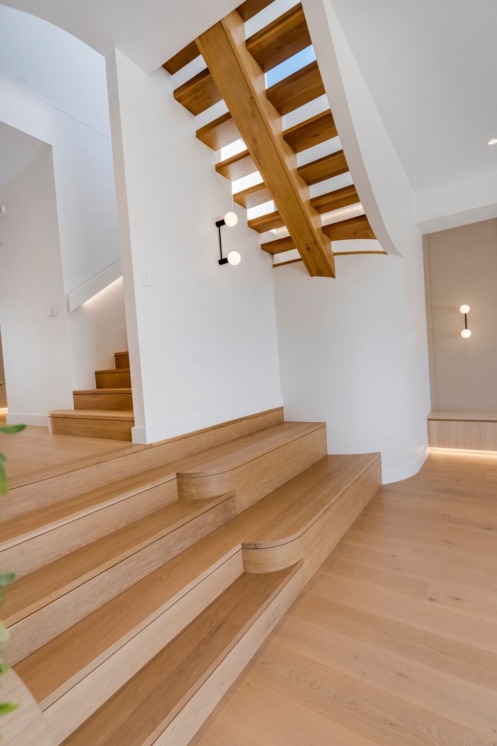 A marble feature panel and full-height oak joinery give the kitchen its quiet presence.