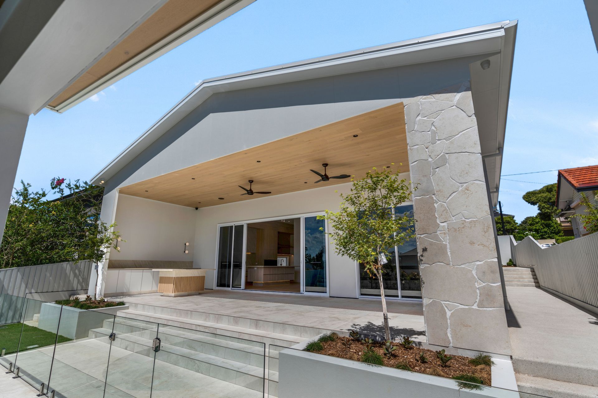 A board-formed concrete pillar anchors the alfresco, ceiling fans keeping it comfortable year round.