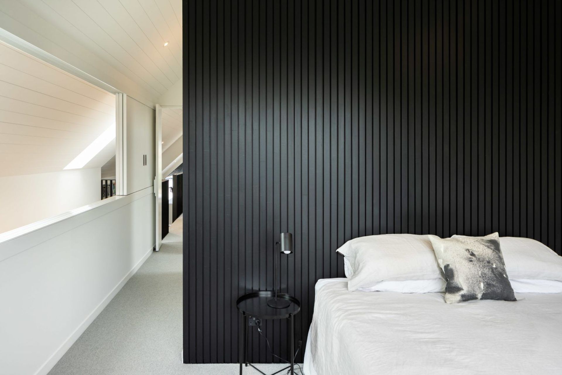 The monochromatic palette is continued inside in the master bedroom.