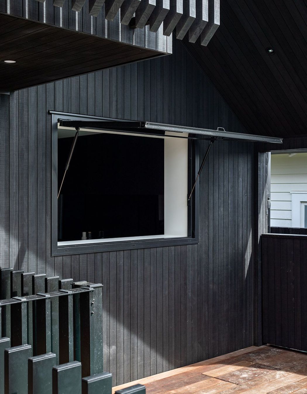 A gas strut window functions as a servery so that kids and guests don't have to come inside to get a drink or snack.