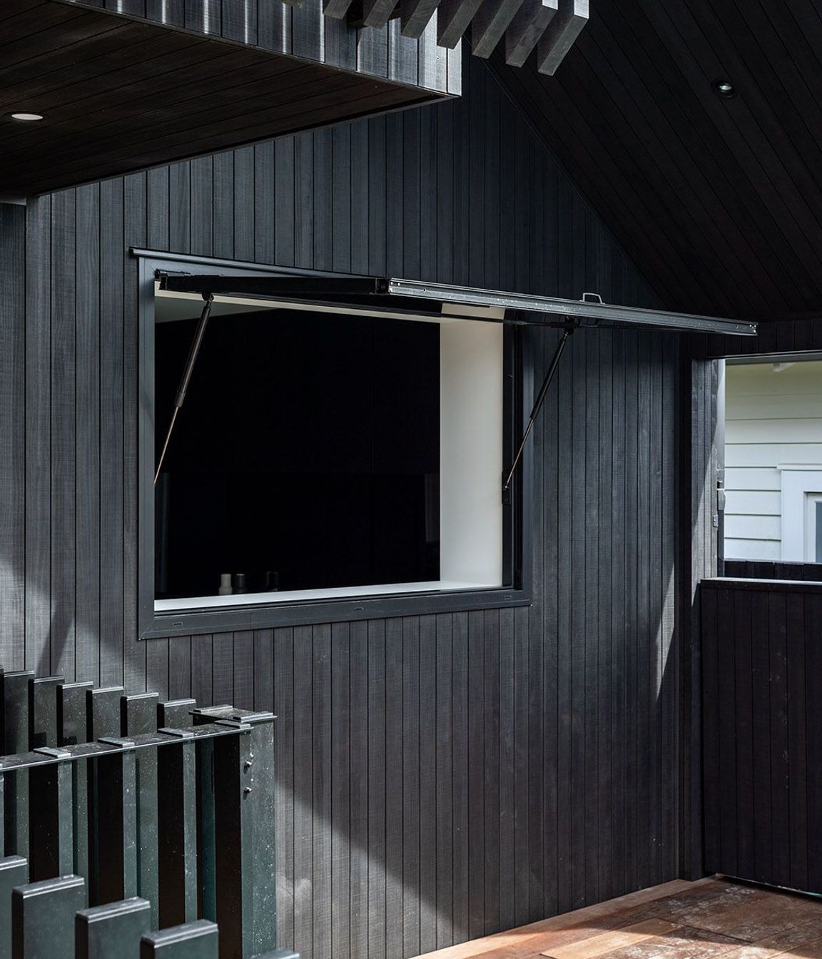 A gas strut window functions as a servery so that kids and guests don't have to come inside to get a drink or snack.