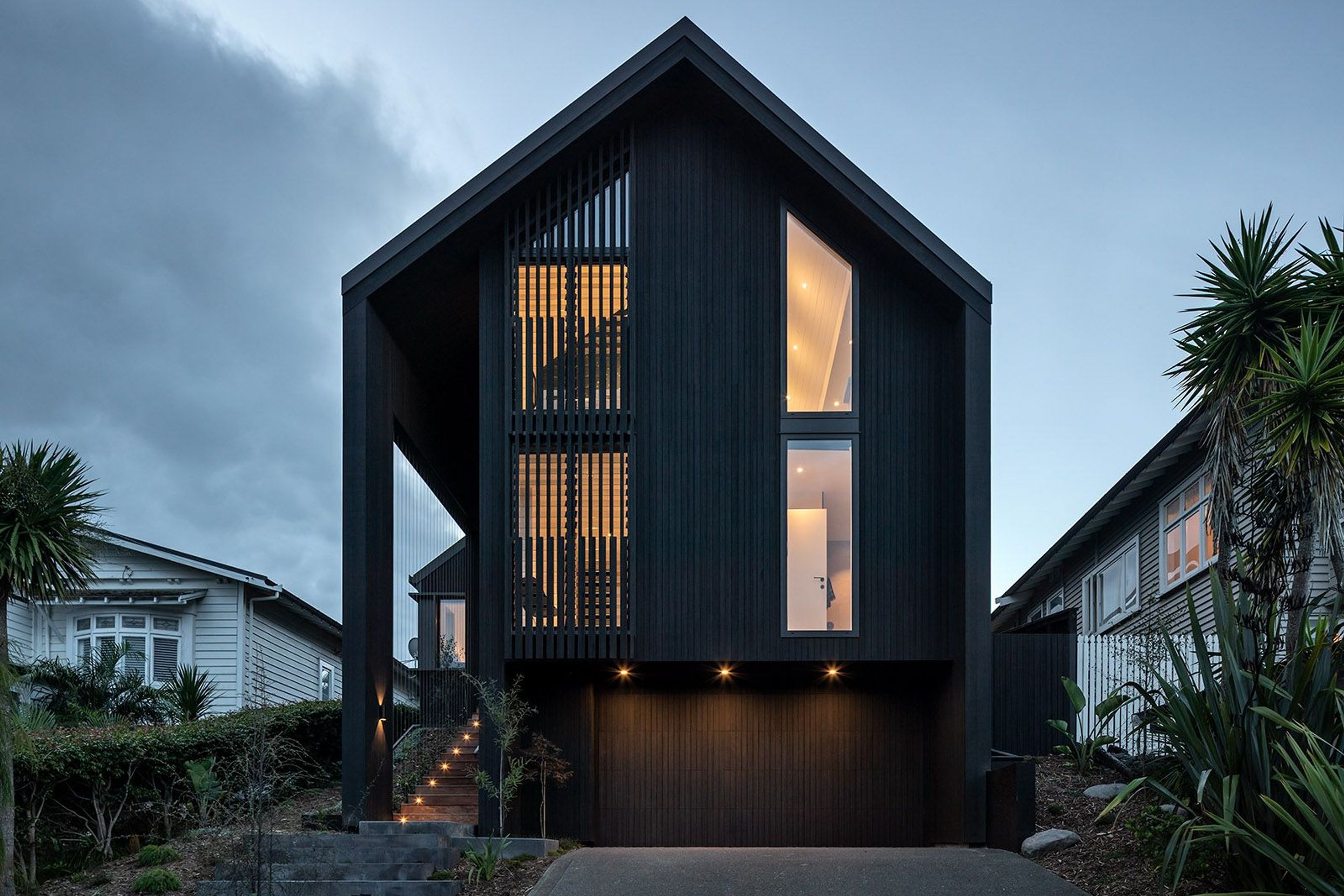The existing rooflines were removed and the home was wrapped with two new slipped gable forms, simplifying the overall shape and gaining an upper level.
