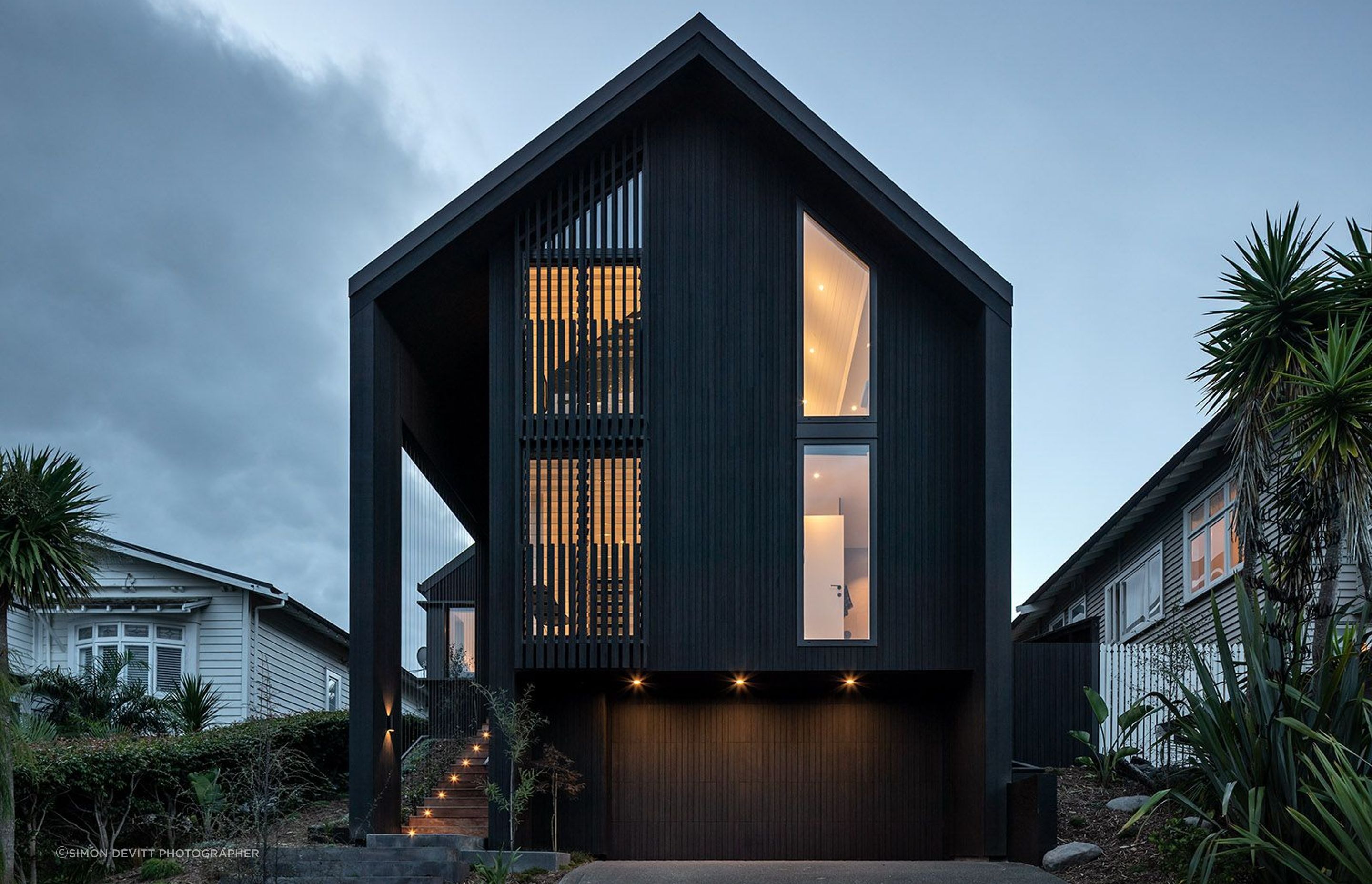 The existing rooflines were removed and the home was wrapped with two new slipped gable forms, simplifying the overall shape and gaining an upper level.