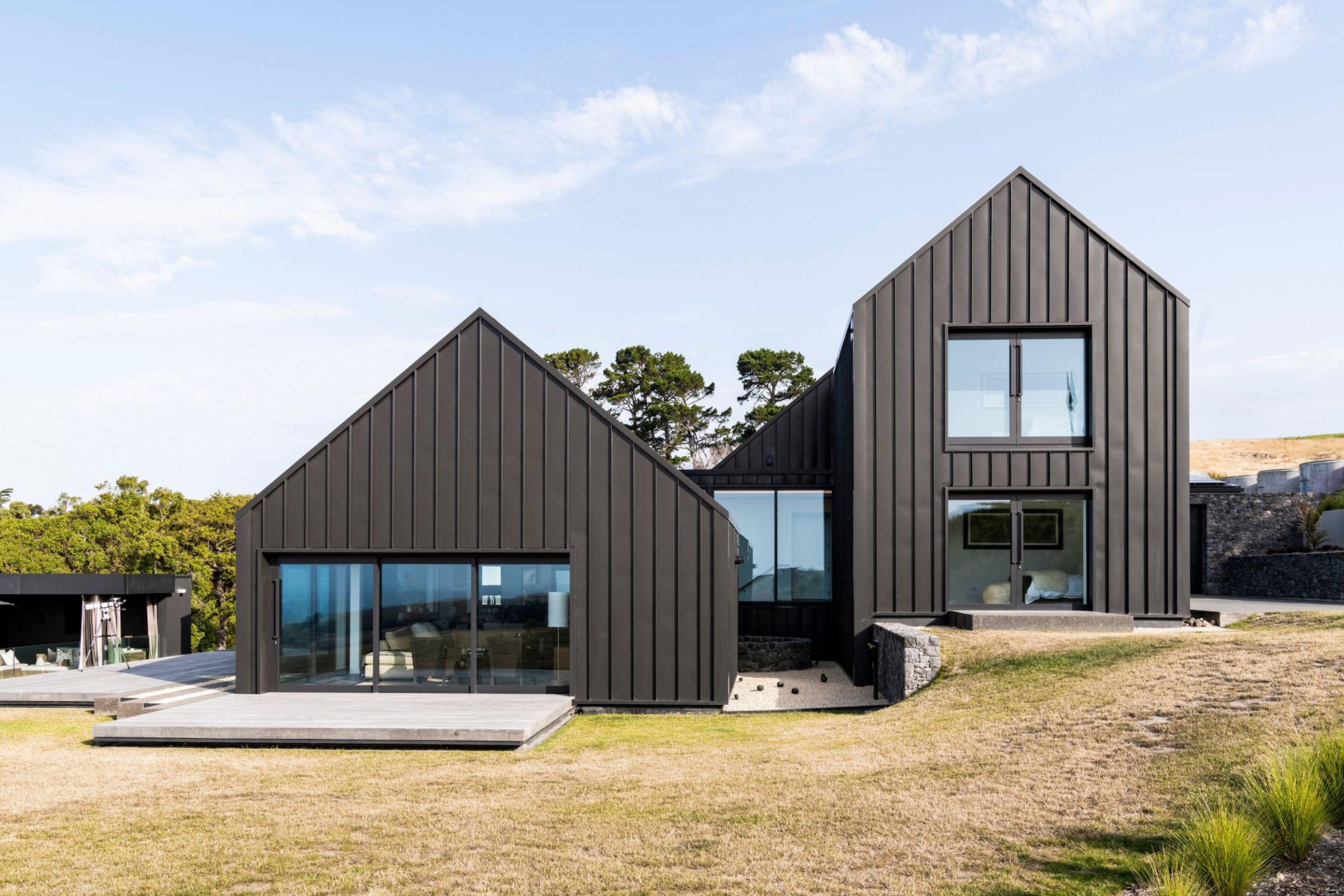 The gable form containing the living spaces steps down from the two-storey gable form containing accommodation.