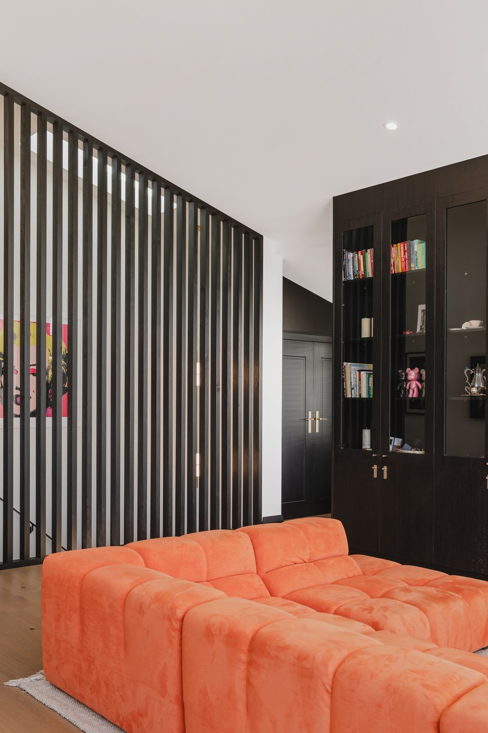 Westmere Bungalow | New-Build Residence | Internal view of open plan living space, including bespoke black shelving with brass accents and italian leather couch.