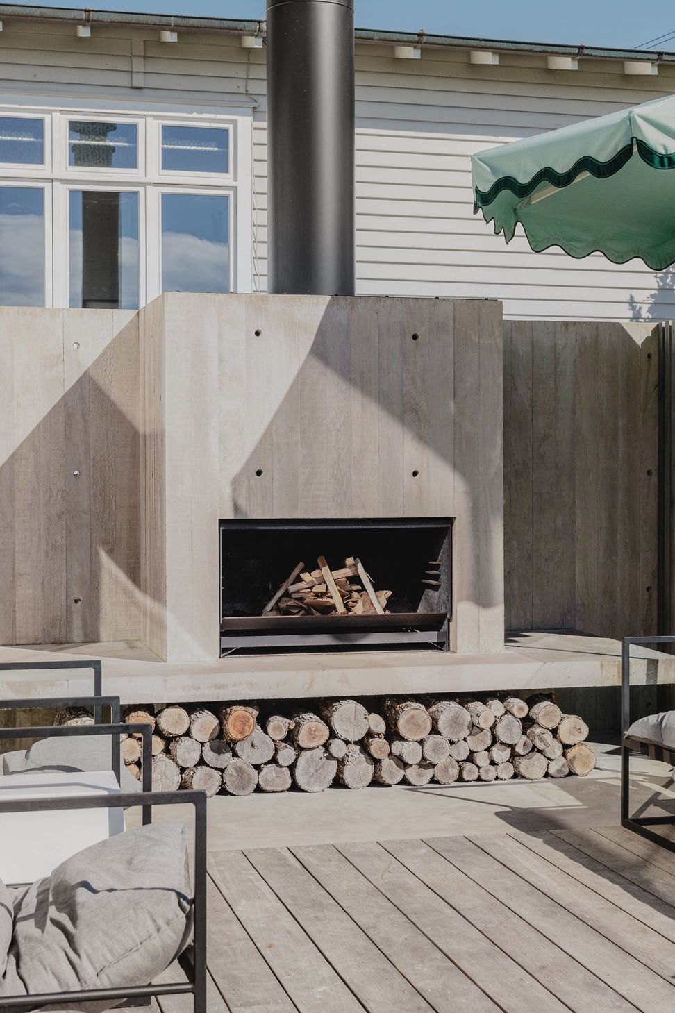 Westmere Bungalow | New-Build Residence | External view of insitu concrete fireplace, sitting right next to the pool area.