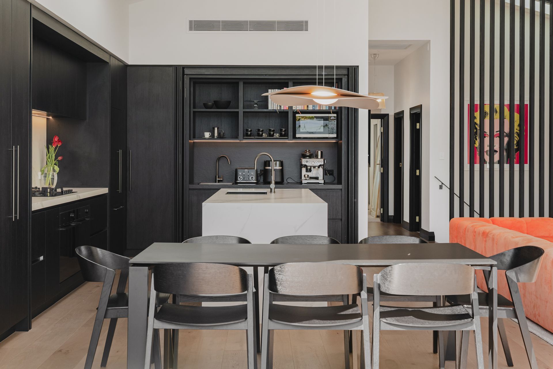 Westmere Bungalow | New-Build Residence | Internal view of bespoke dark kitchen design, featuring cabinetry that conceals a coffee station and marble waterfall island bench.