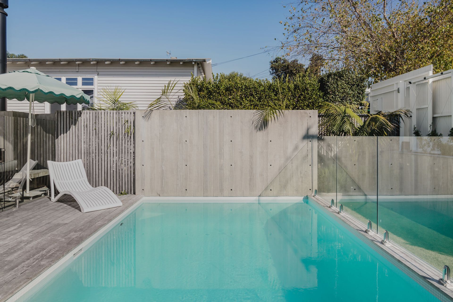 Westmere Bungalow | New-Build Residence | External view of insitu concrete feature wall and concrete salt water swimming pool.