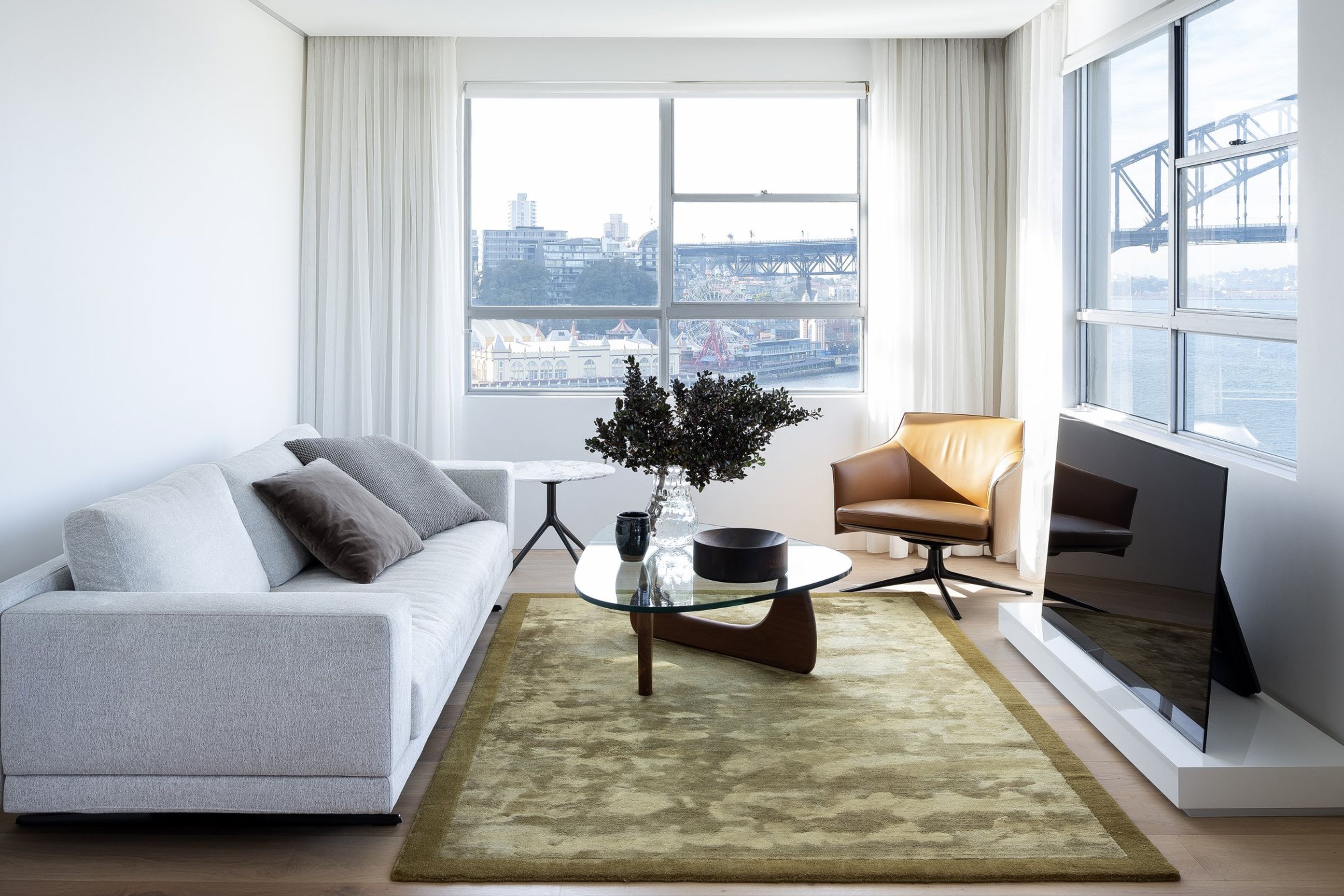 Poliform's Mondrian sofa and Stanford armchair all feature in the McMahons Point apartment along with the Poliform Frame rug in olive green bamboo and silk.