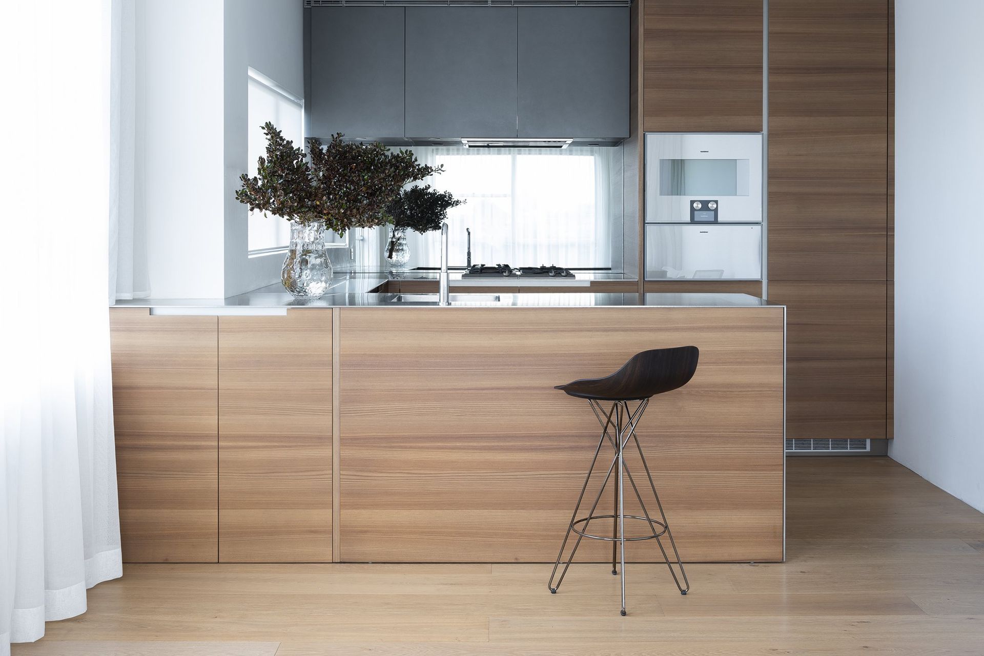 Poliform Phoenix kitchen with longitudinal elm veneer finish and Poliform Harmony stool.
