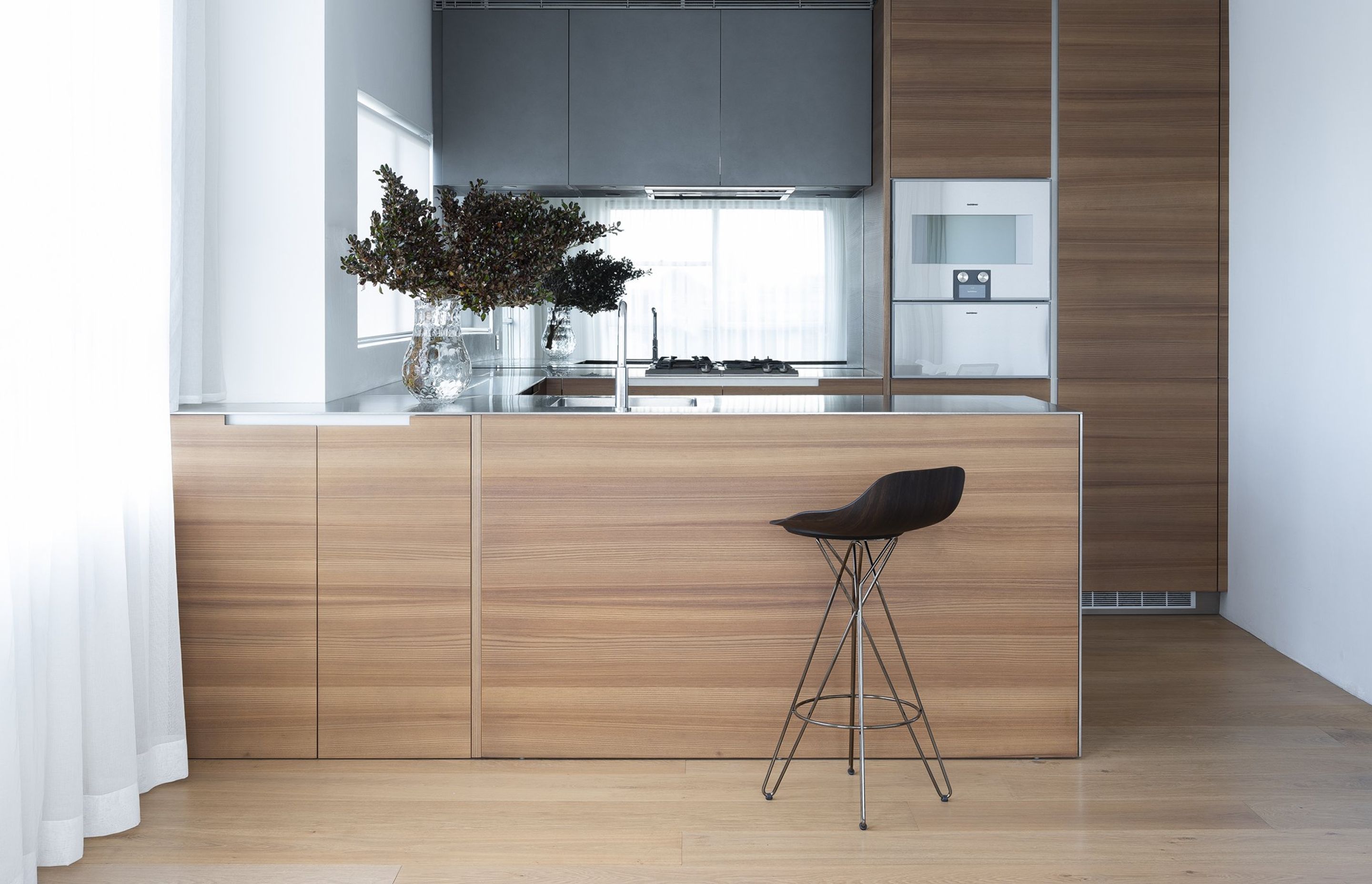 Poliform Phoenix kitchen with longitudinal elm veneer finish and Poliform Harmony stool.