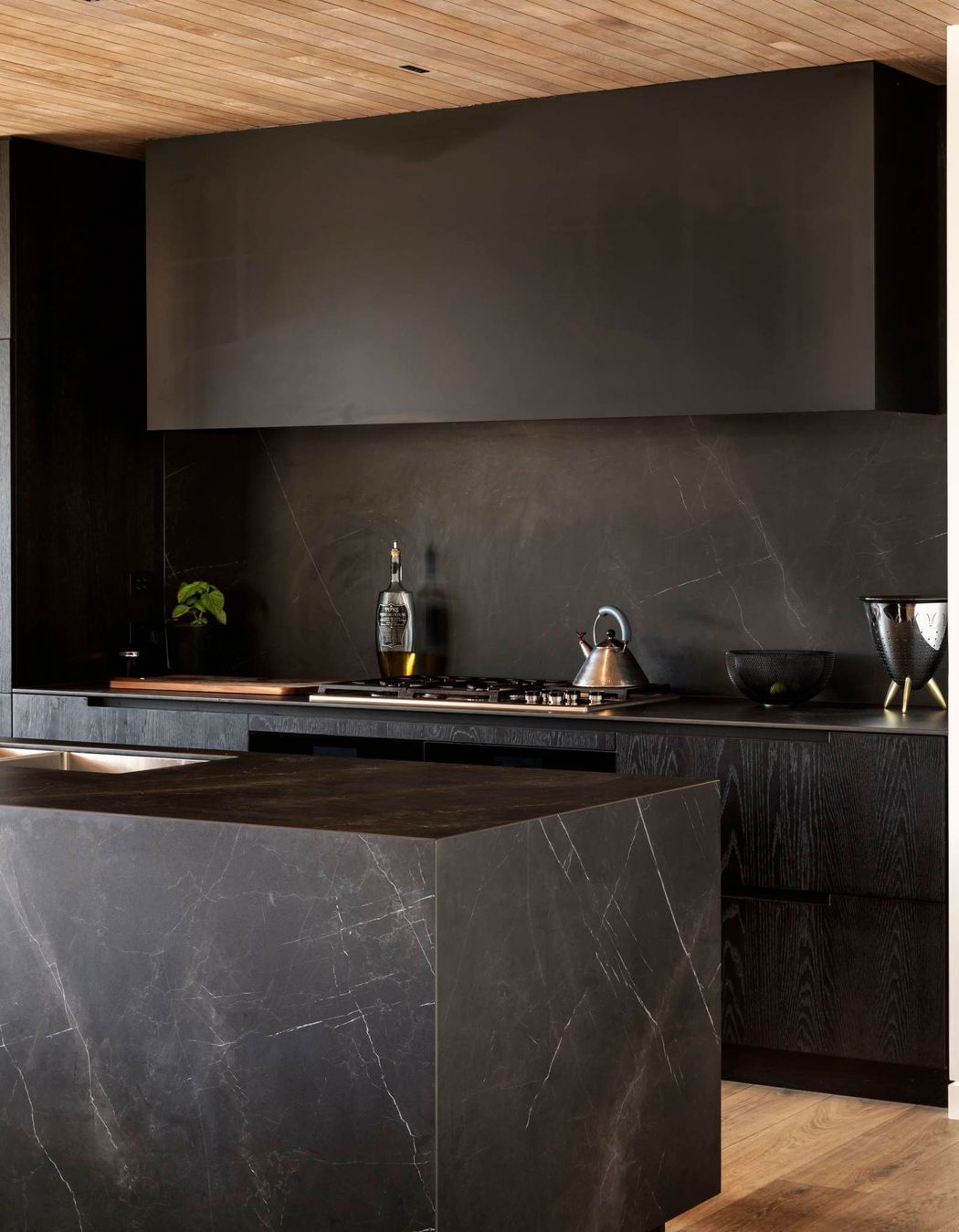 Kitchen designer Morgan Cronin set up a moody textural feel for the kitchen through tone-on-tone marble-effect porcelain and darkly stained oak.