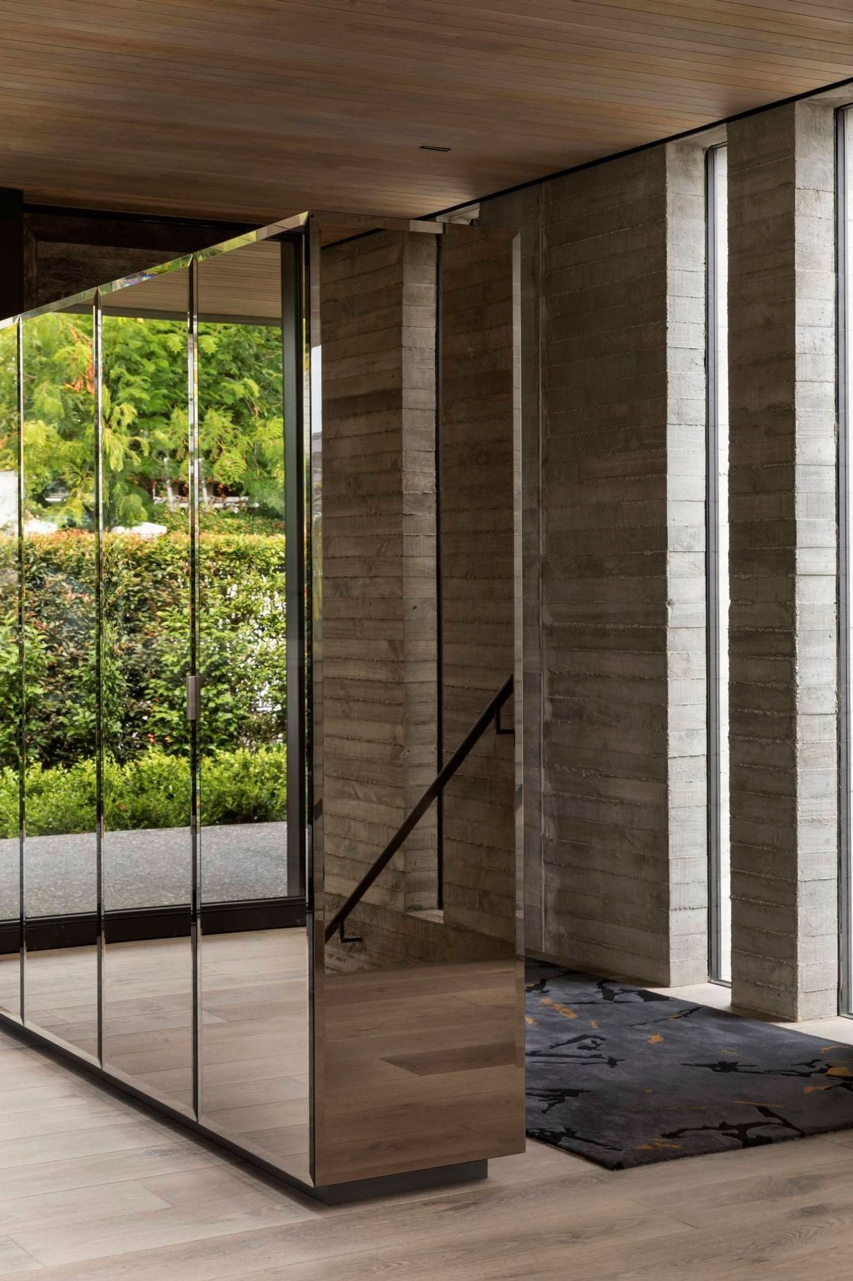 A built-in, mirrored unit separating the entry space from the dining area adds much-needed storage but also reflects the afternoon courtyard back into the house, making it visually accessible from almost any angle.