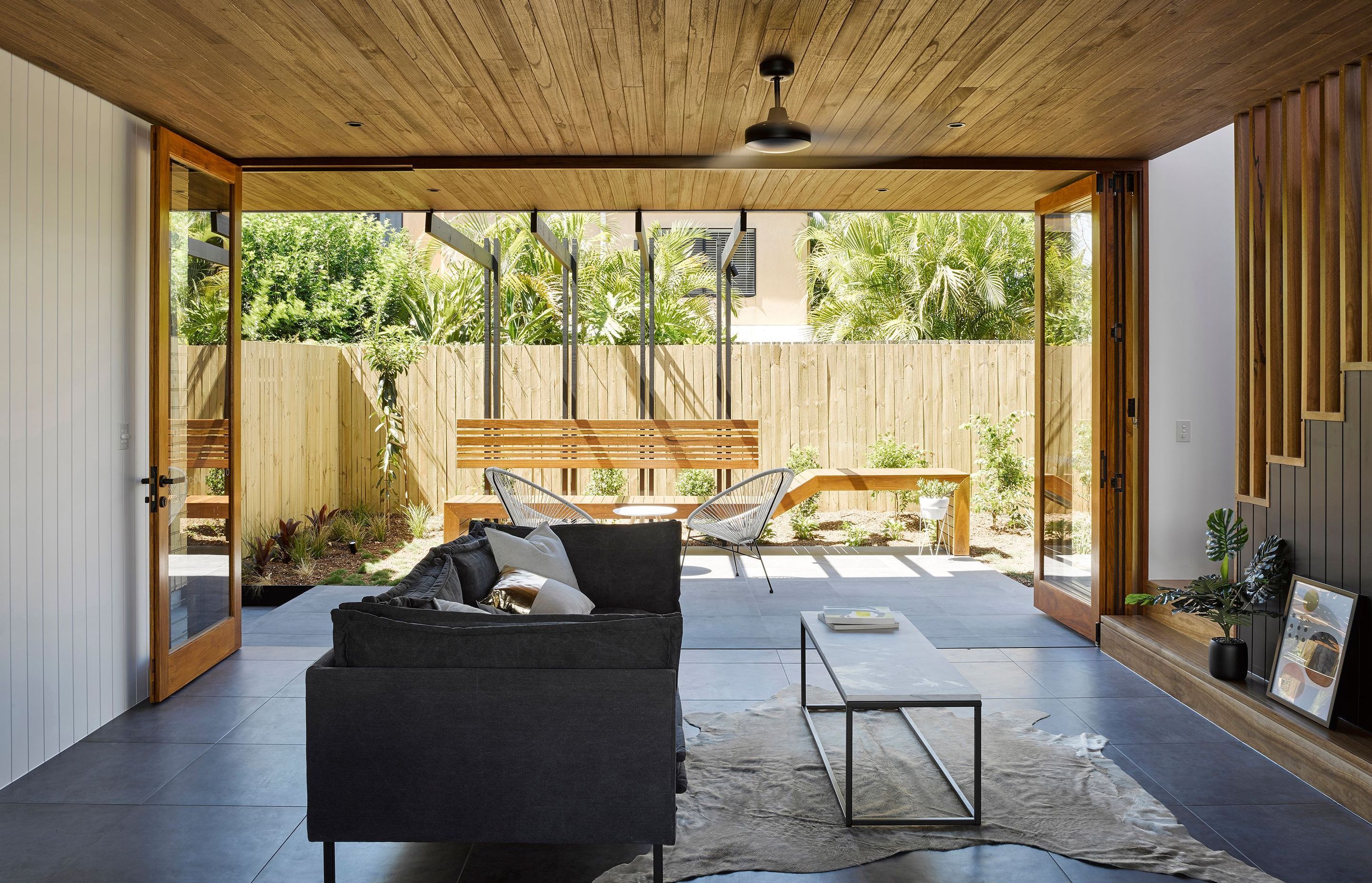 Photography: Christopher Frederick Jones, Roger D’Souza and Cathy Schusler | Living spaces extend into the landscape through the use of full height bi-fold doors. Floor and ceiling finishes seamlessly continue outside to further add to the feeling of spac