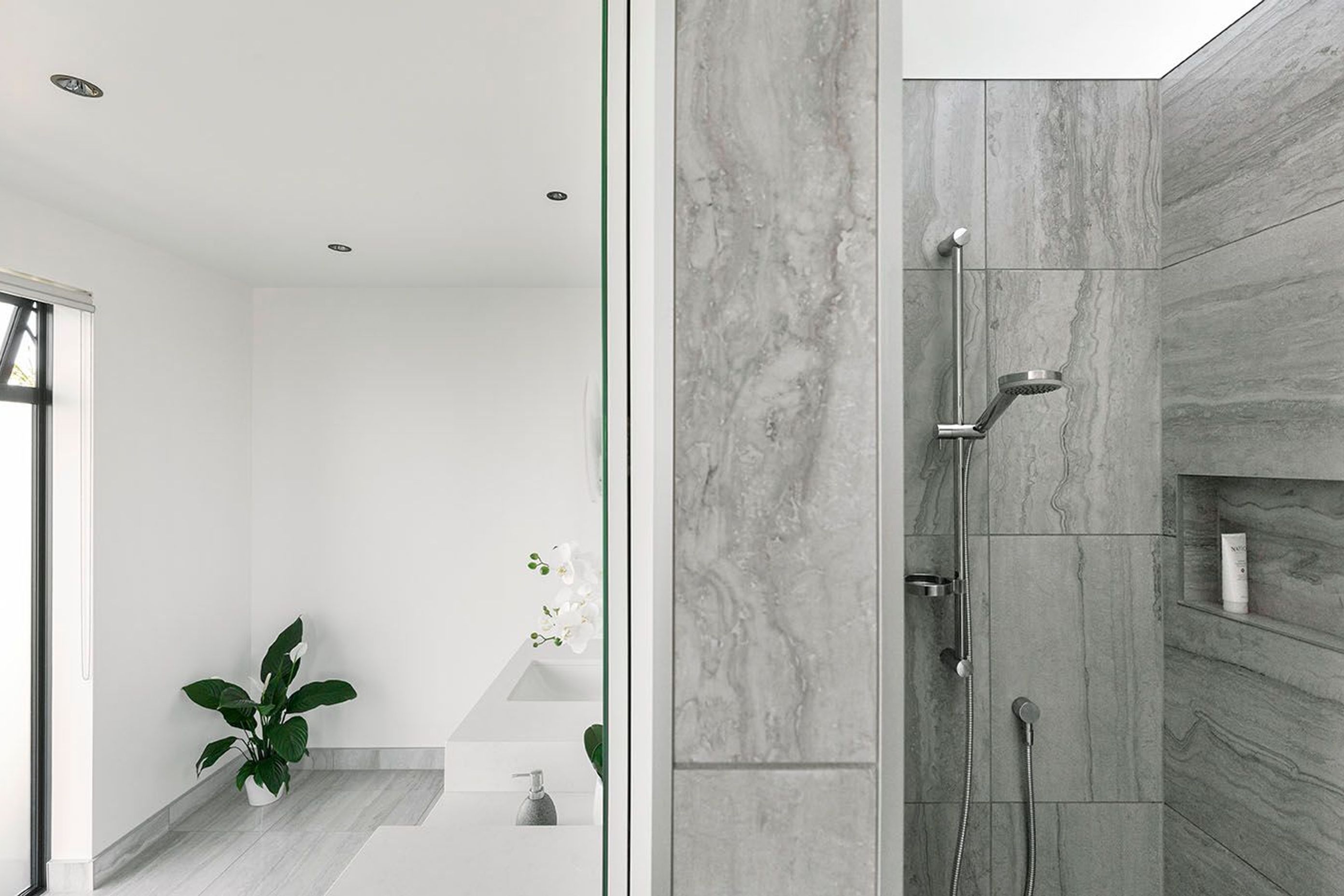 Bathroom features open spaces to enter on both sides, one to the walk in shower and other to the toilet, a double basin adorns the front wall