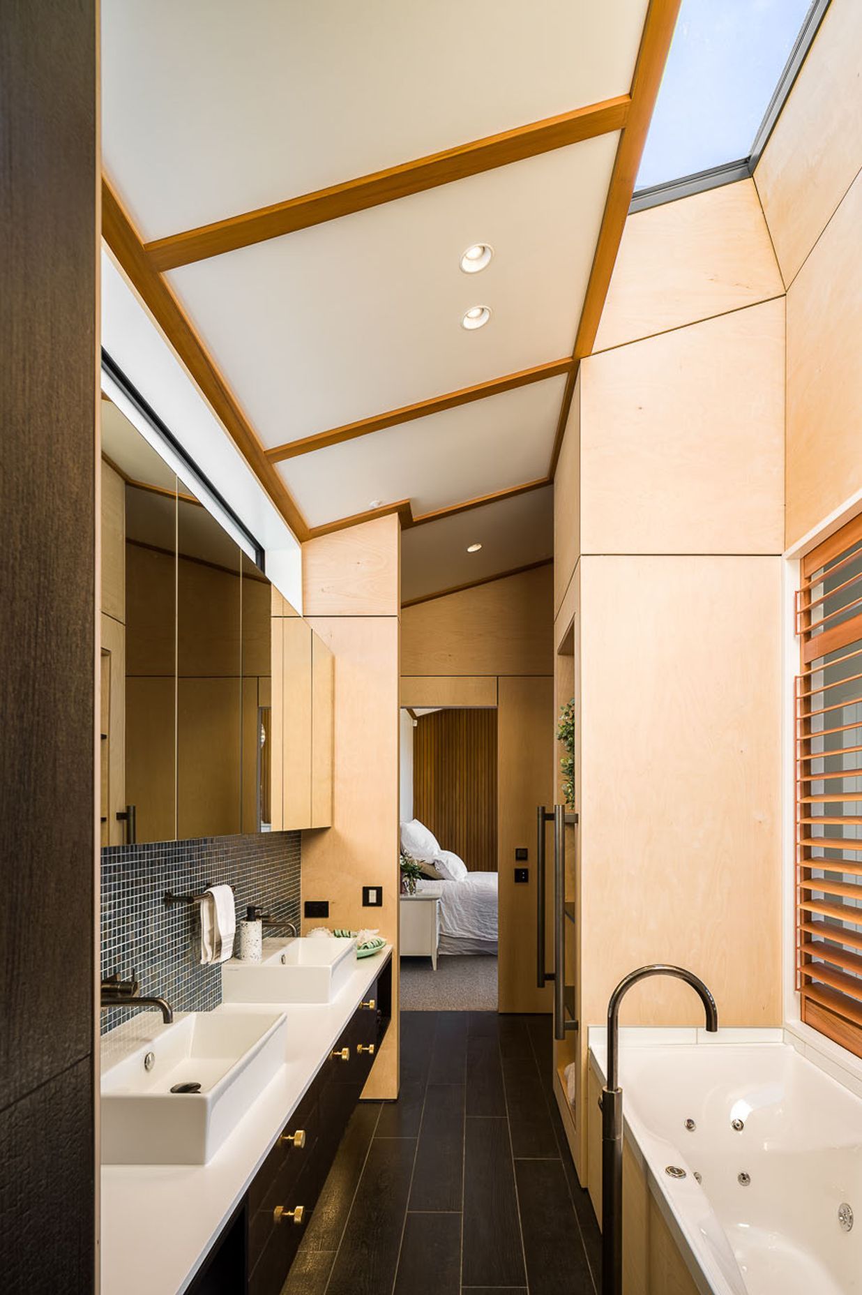 Located behind the break-out space, the ensuite uses a mix of clerestory and internal windows, as well as a skylight to bring light into the space.