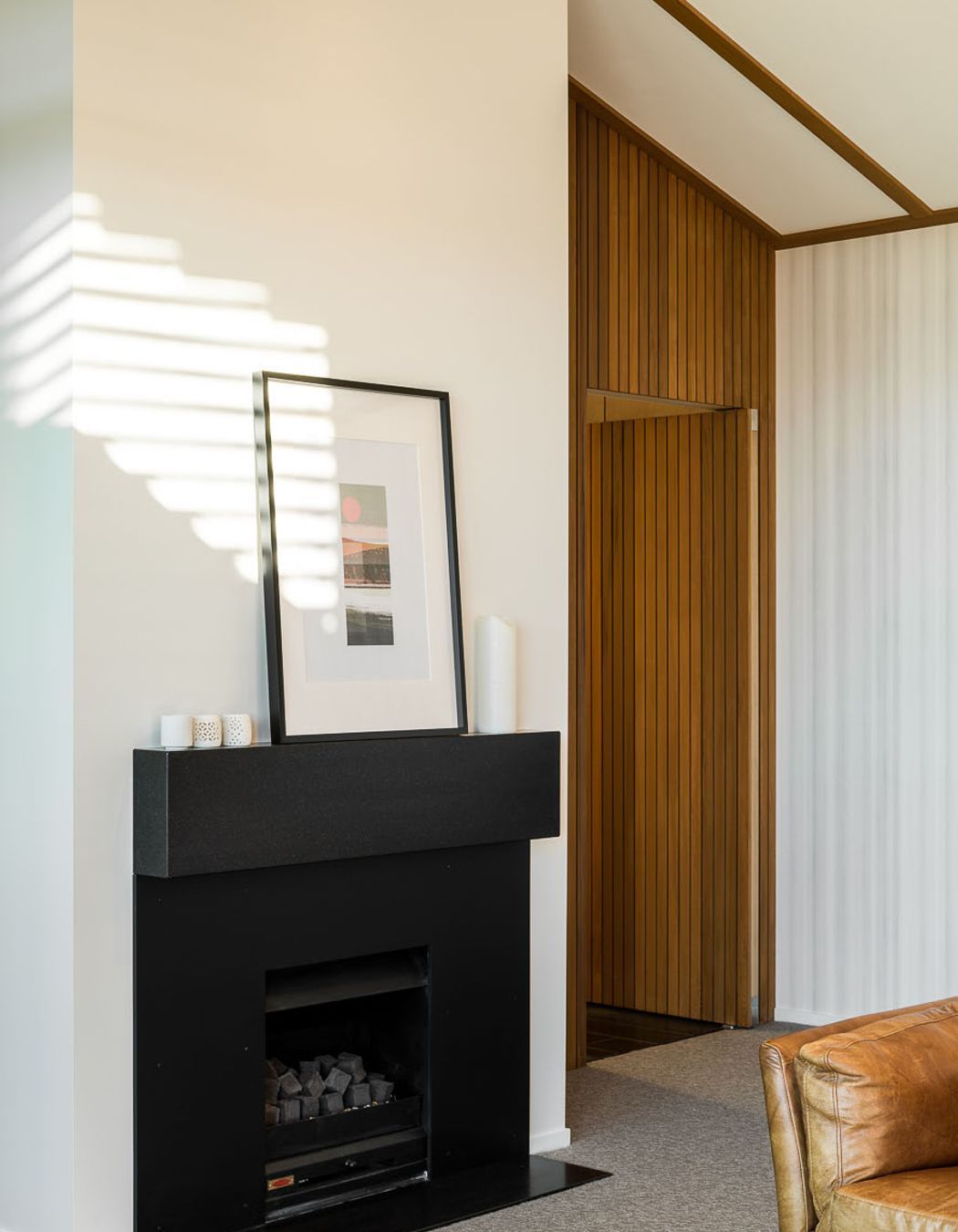 Shiplap on the door creates a seamless look and complements the crisp colour palette. The ceiling plane follows the roofline for an added sense of volume and space.