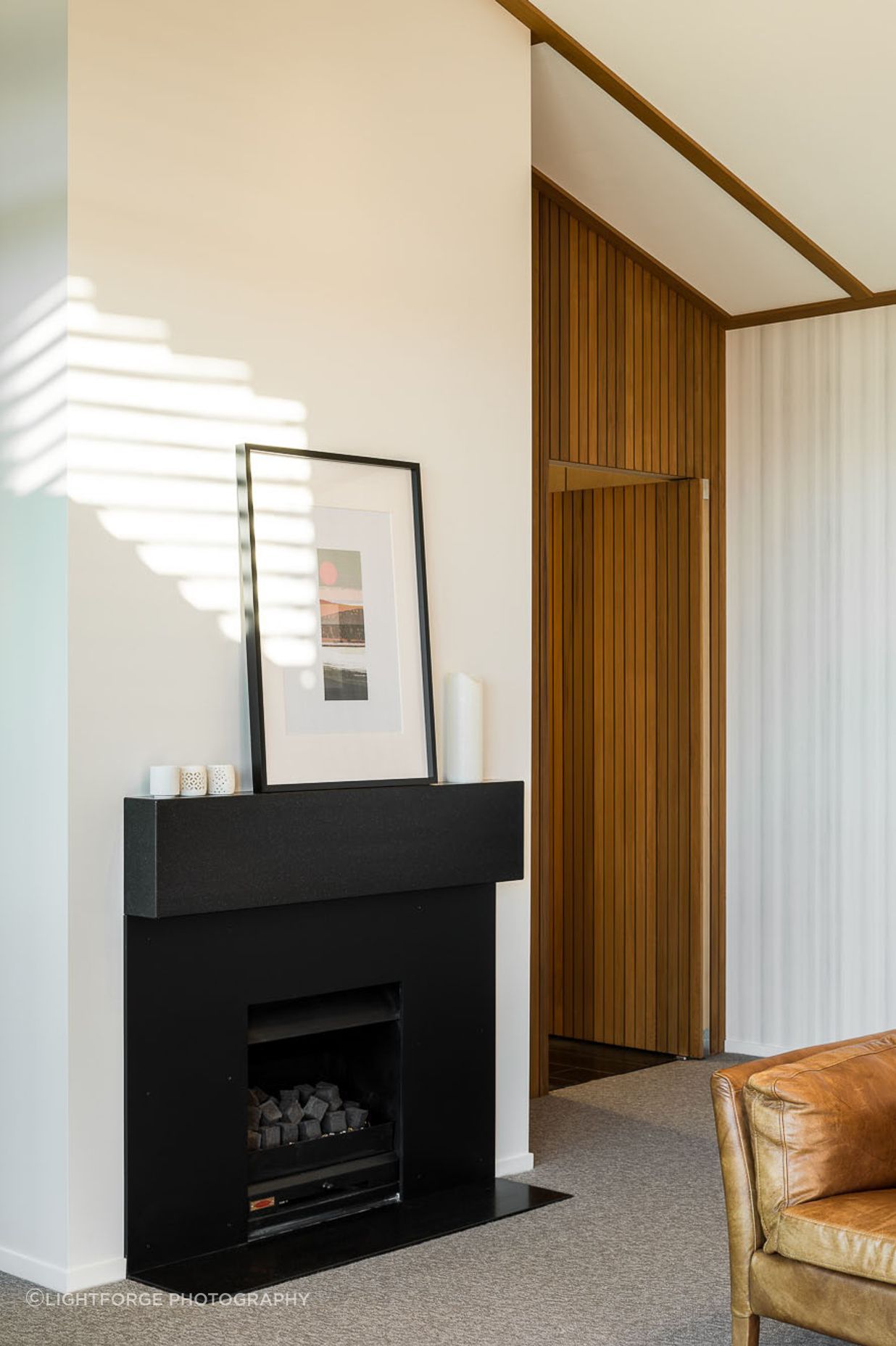 Shiplap on the door creates a seamless look and complements the crisp colour palette. The ceiling plane follows the roofline for an added sense of volume and space.