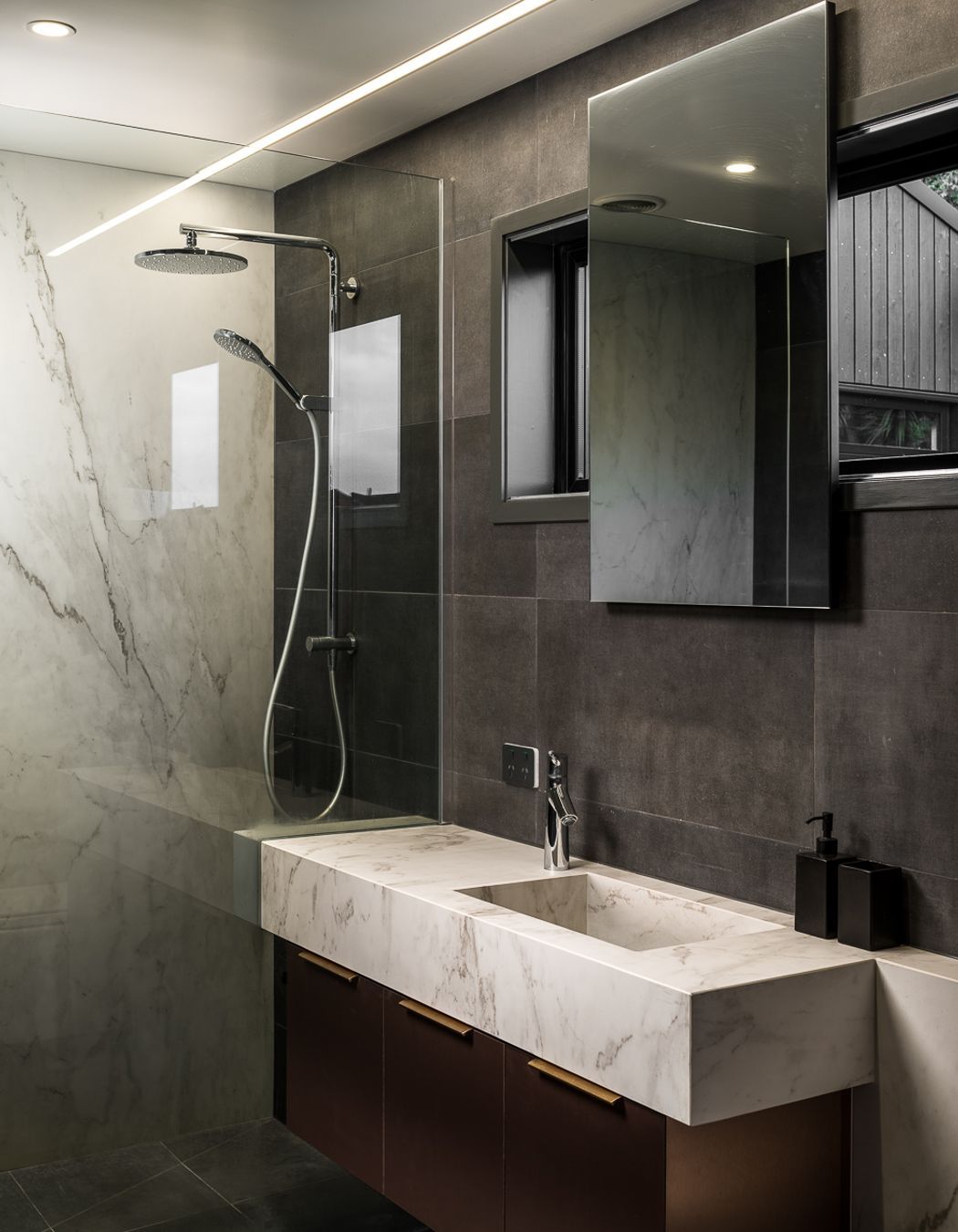 The understated yet richly textural palette continues in the bathroom with its mix of stone and timber.