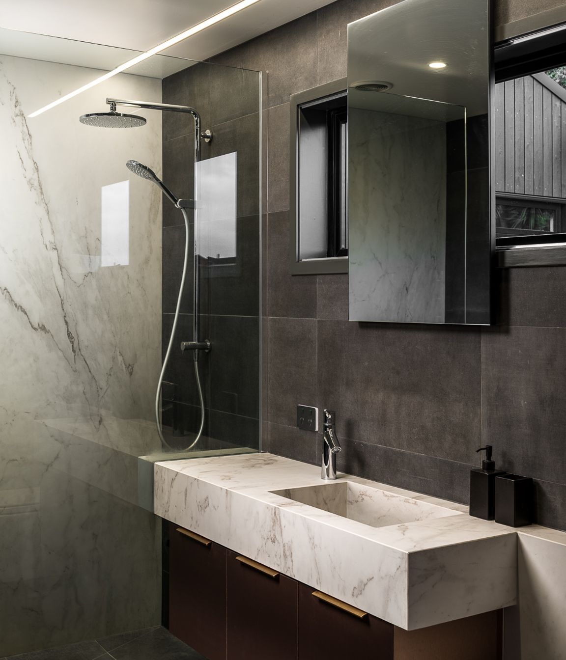 The understated yet richly textural palette continues in the bathroom with its mix of stone and timber.