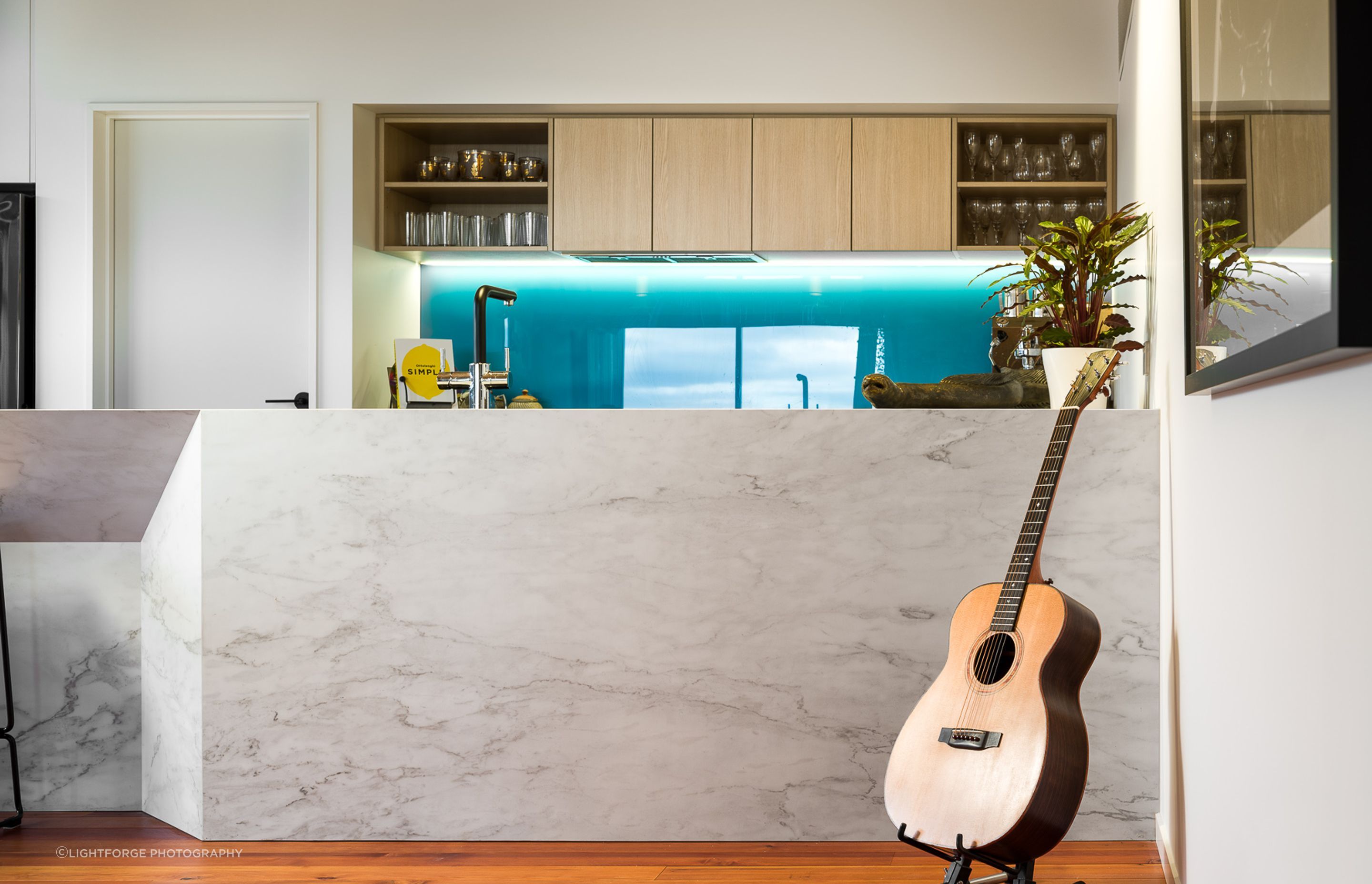 A large, faceted marble island adds further architectural interest to the open-plan living space.