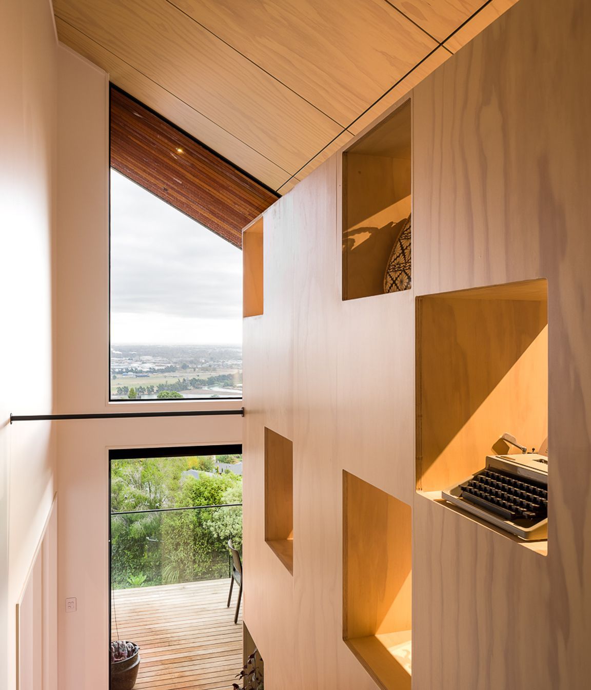 Open apertures in the large bookcase element serve to admit diffused light onto the stairs.