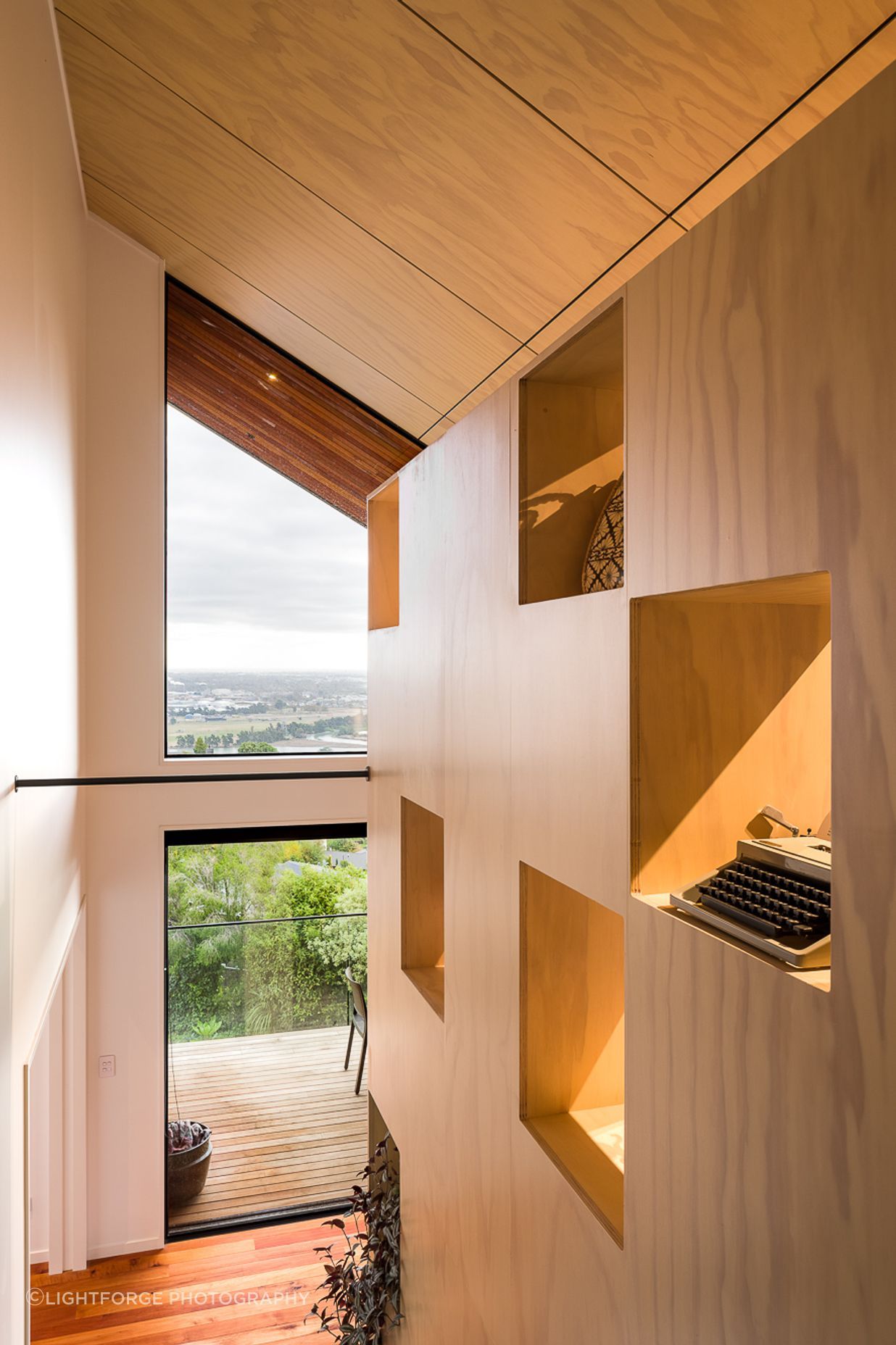 Open apertures in the large bookcase element serve to admit diffused light onto the stairs.