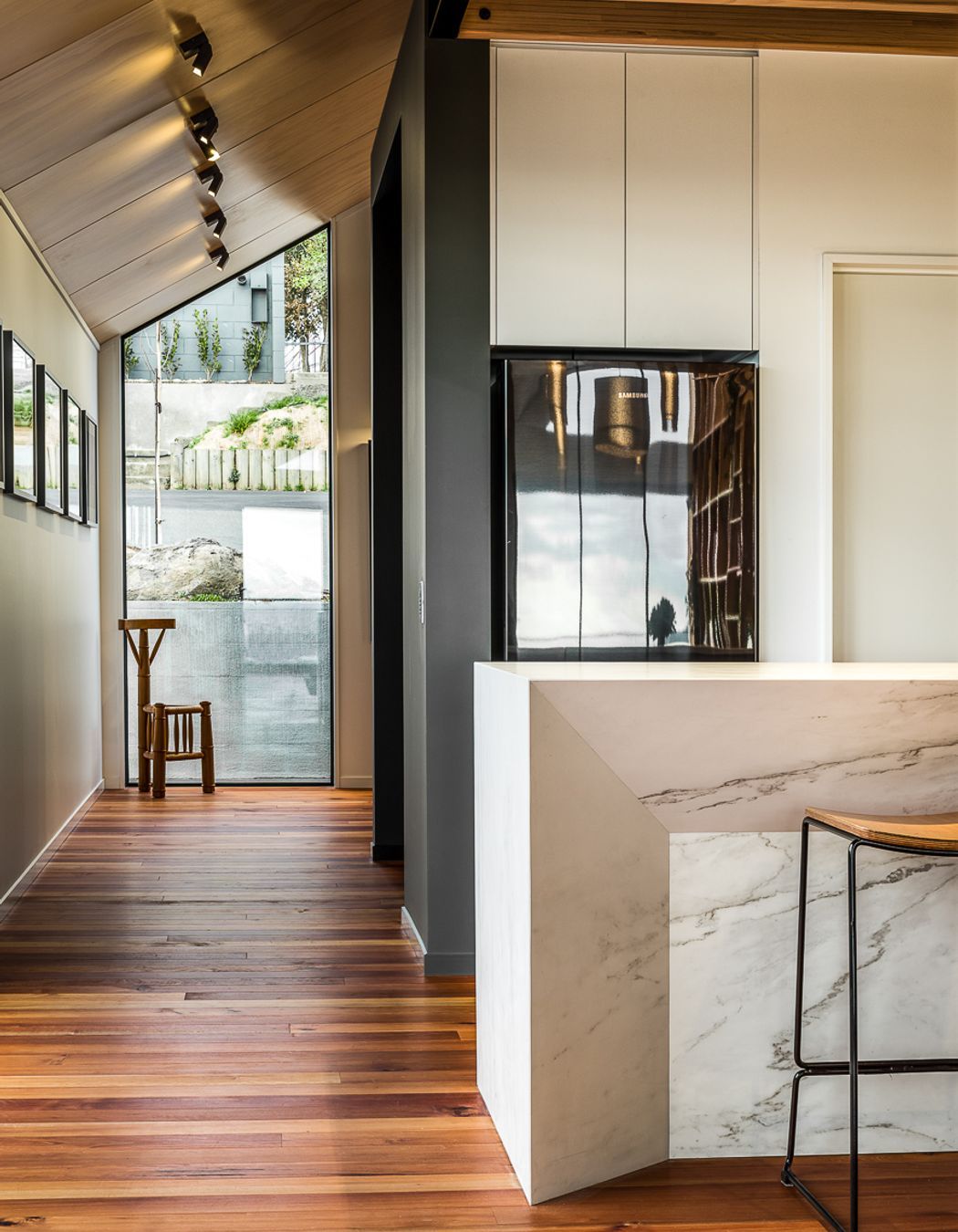 A floor-to-ceiling window on the street side of the house helps bring light into the entryway.