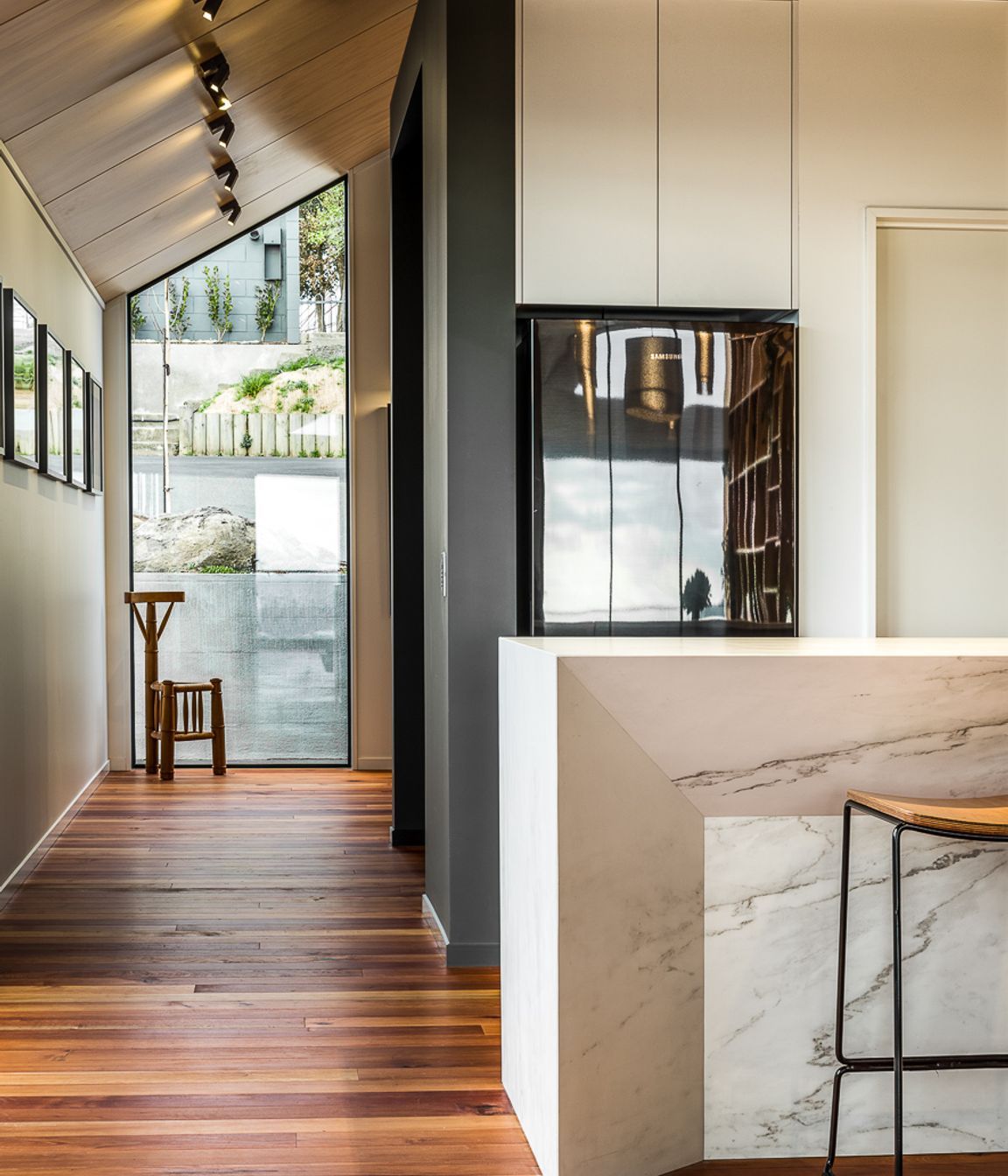 A floor-to-ceiling window on the street side of the house helps bring light into the entryway.