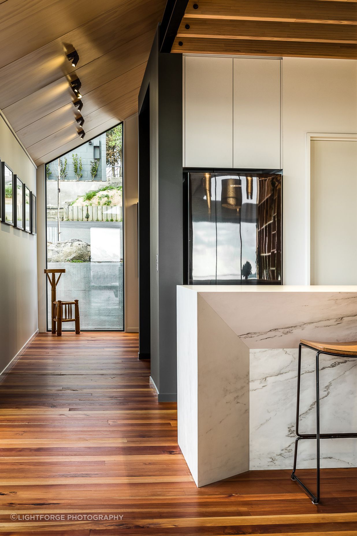 A floor-to-ceiling window on the street side of the house helps bring light into the entryway.