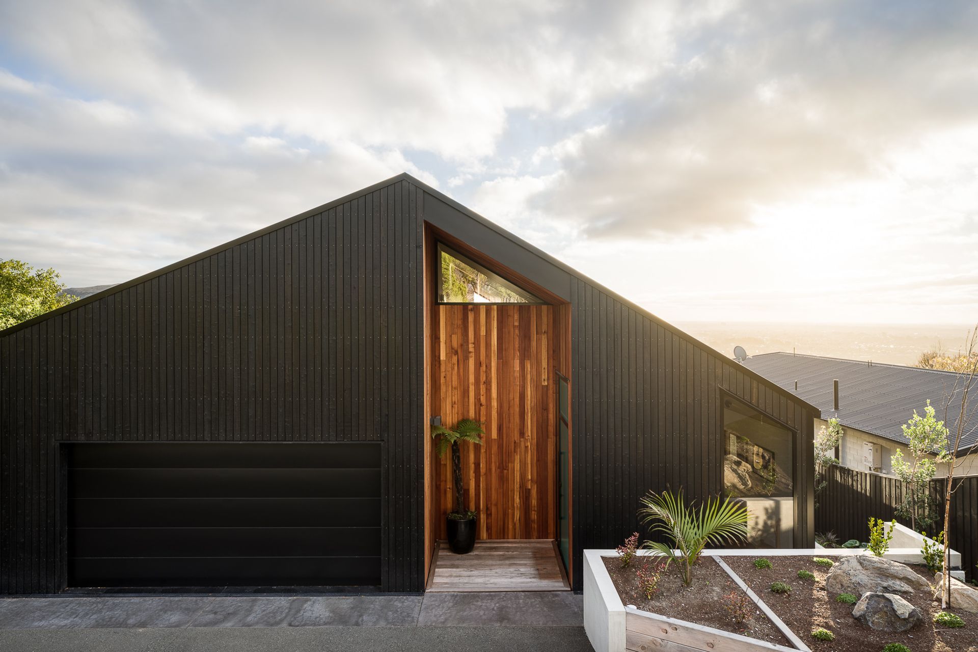 A series of niches have been 'carved' into the home's exterior and lined with red beech to add warmth to the yakisugi cladding.