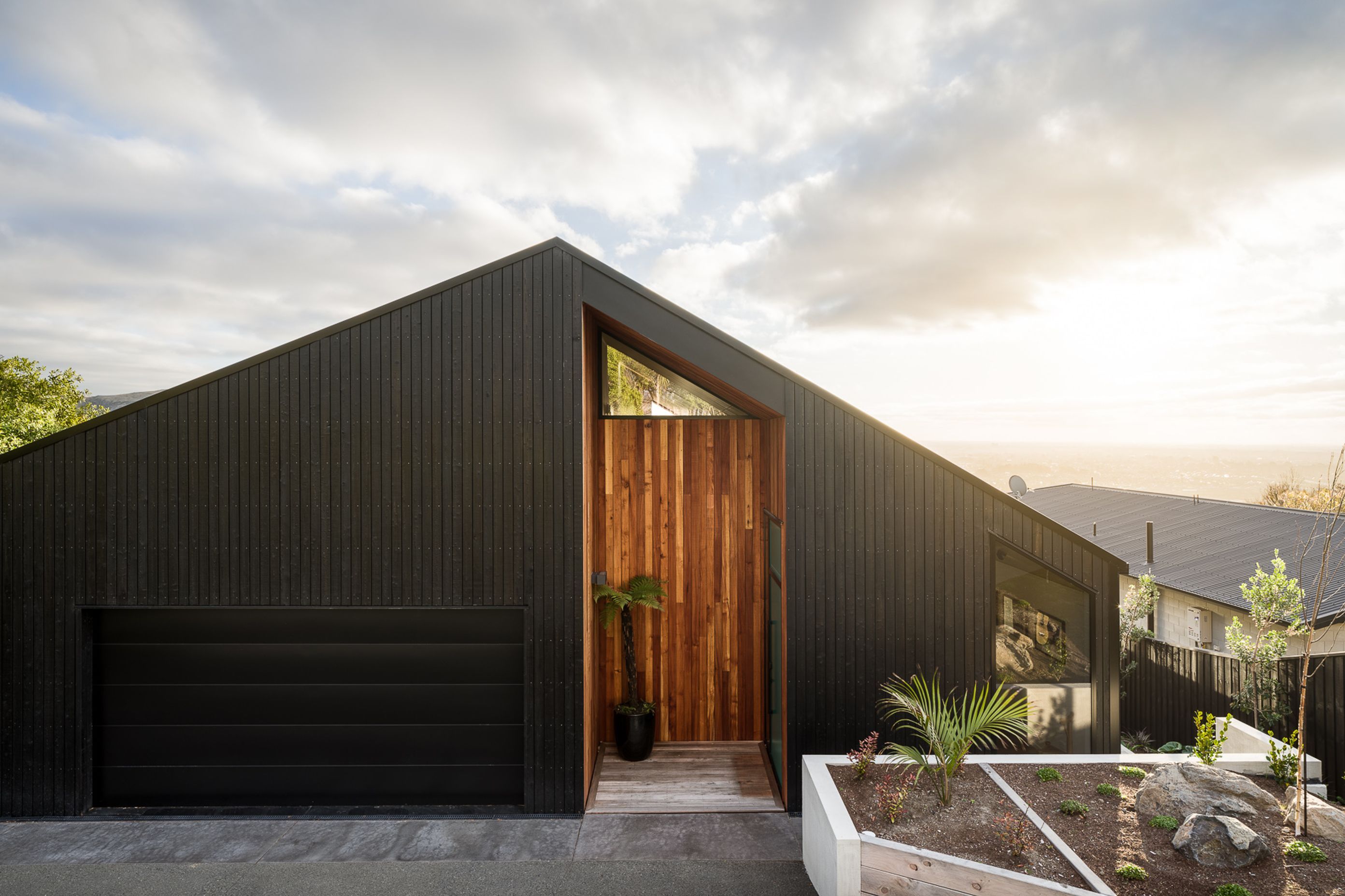 A series of niches have been 'carved' into the home's exterior and lined with red beech to add warmth to the yakisugi cladding.