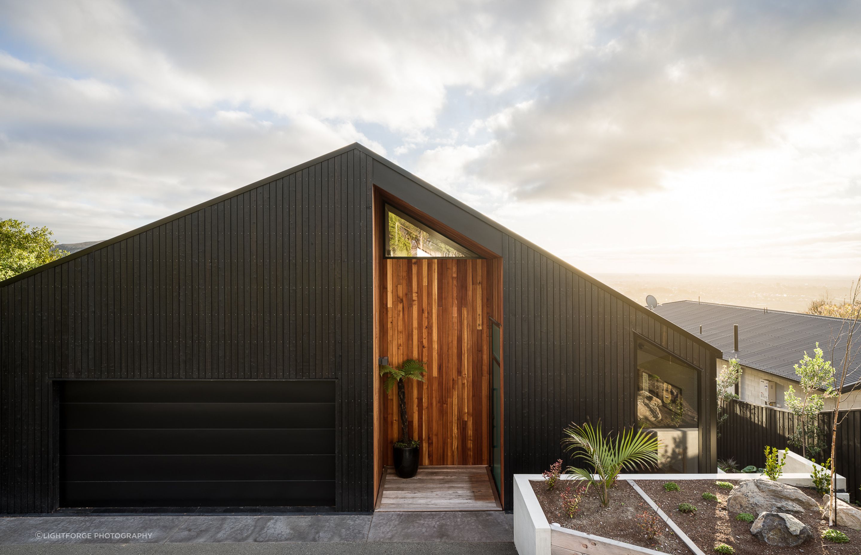 A series of niches have been 'carved' into the home's exterior and lined with red beech to add warmth to the yakisugi cladding.
