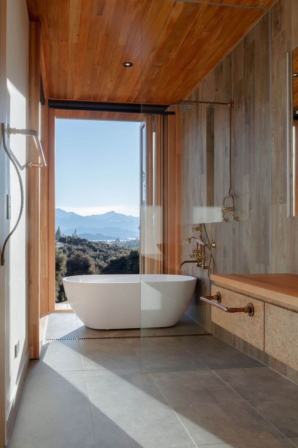 The wet-area shower features an industrial-style exposed copper pipe shower rail.