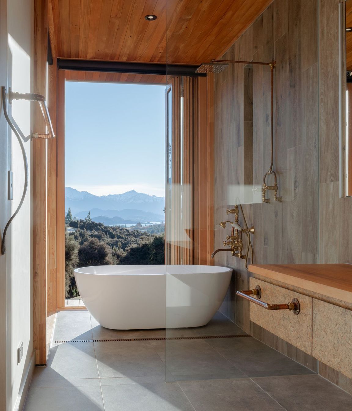 The wet-area shower features an industrial-style exposed copper pipe shower rail.