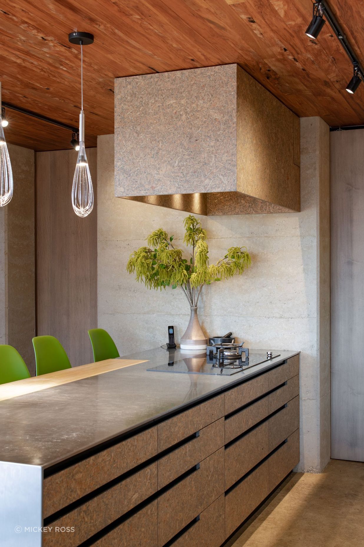 Strand board, a material not usually associated with residential architecture, was chosen for the kitchen cabinetry.