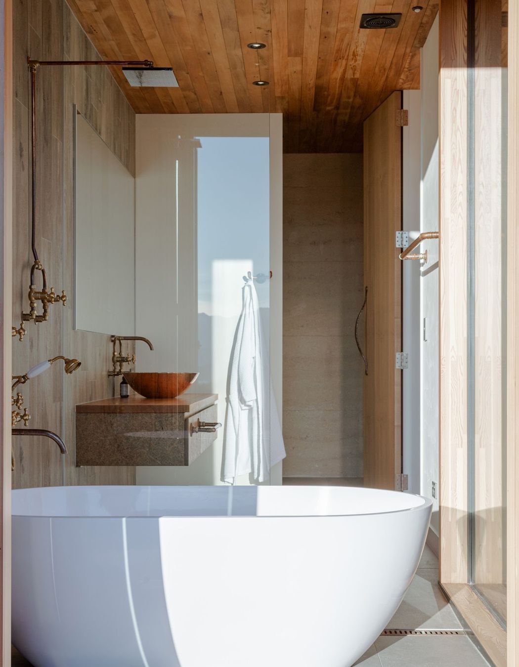 The free-standing bath sits within its own enclave with bifolding doors that open directly to the deck.